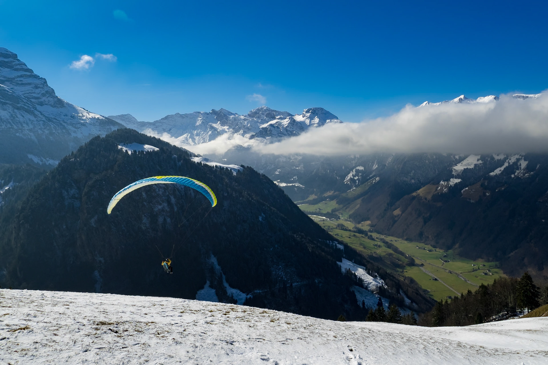 Paraglider starting in front of the Swiss mountain panorama