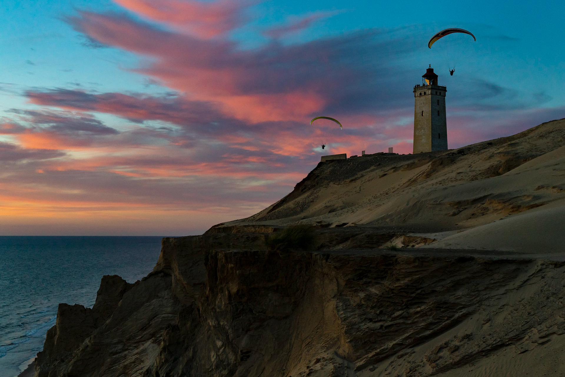 Paragliders soaring near Rubjerg Knude Fyr in Denmark