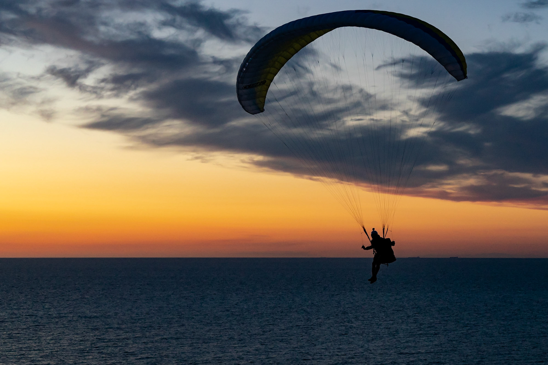Paragliders soaring into the amazing sunset near Lokken Denmark