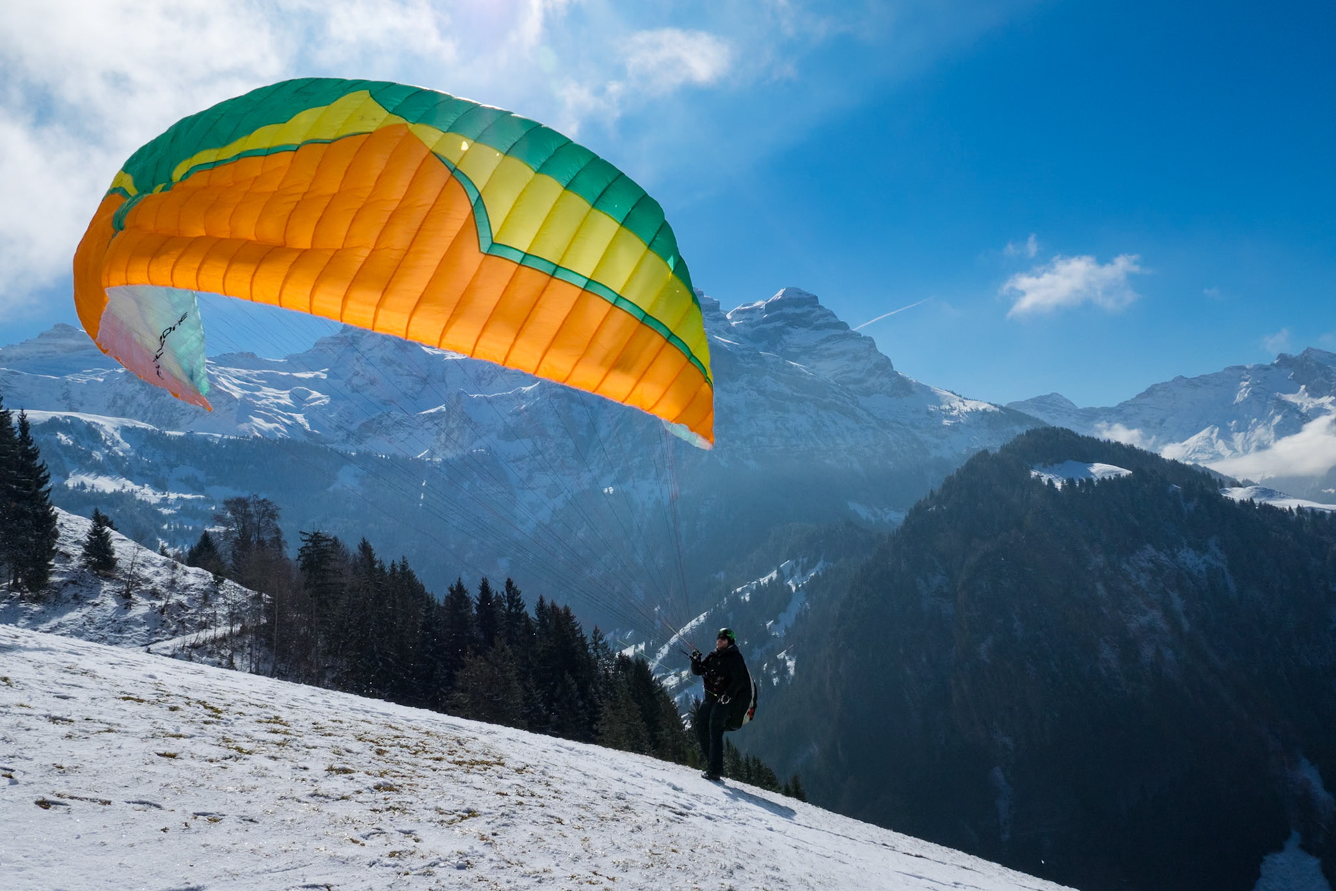 Paraglider starting in front of the Swiss mountain panorama