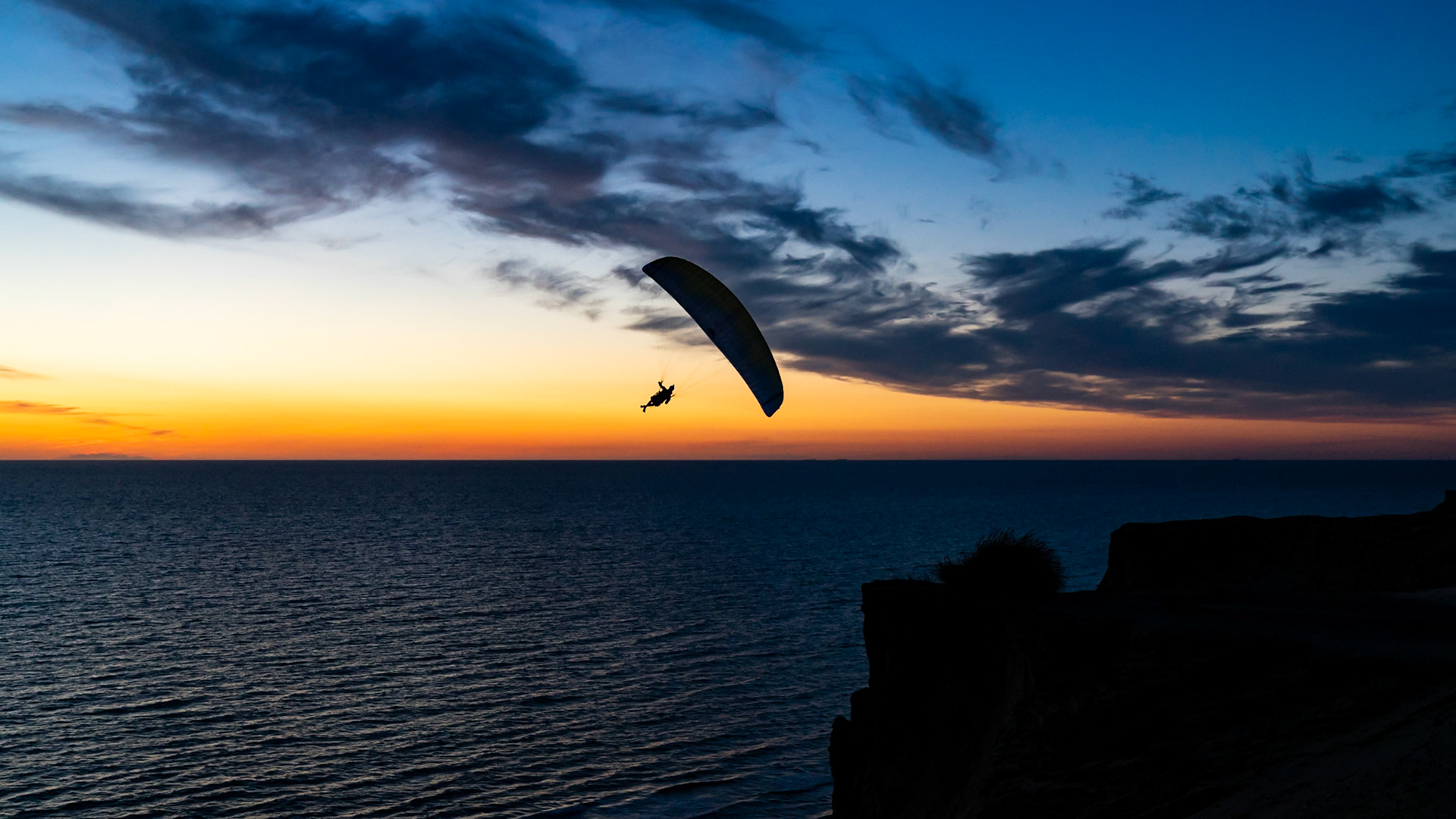 Paragliders soaring into the amazing sunset near Lokken Denmark