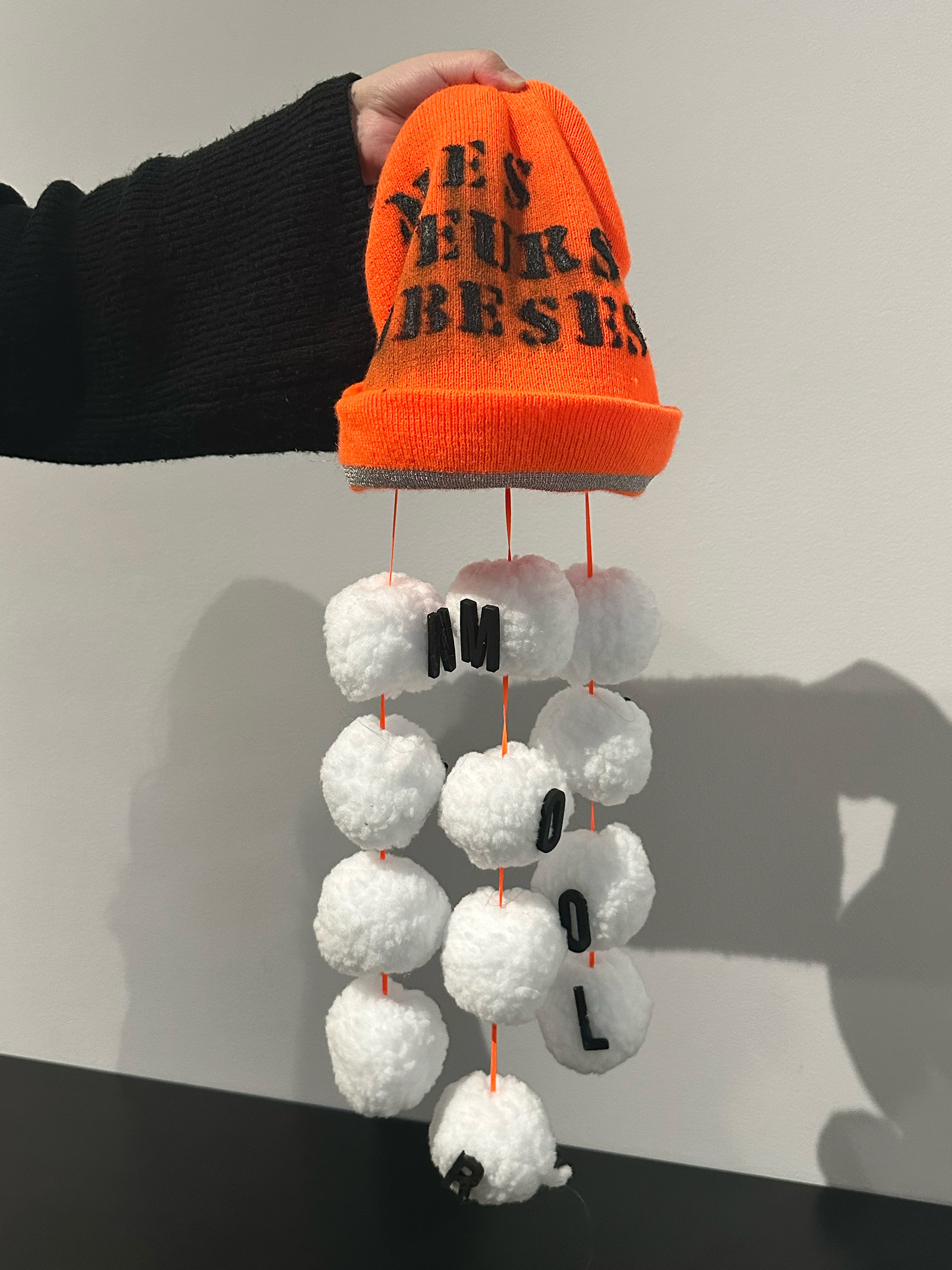 poème mobile intérieur tuque.2023. Ficelle, lettres en foam sur balles de neige en tissus. ©José Dupuis