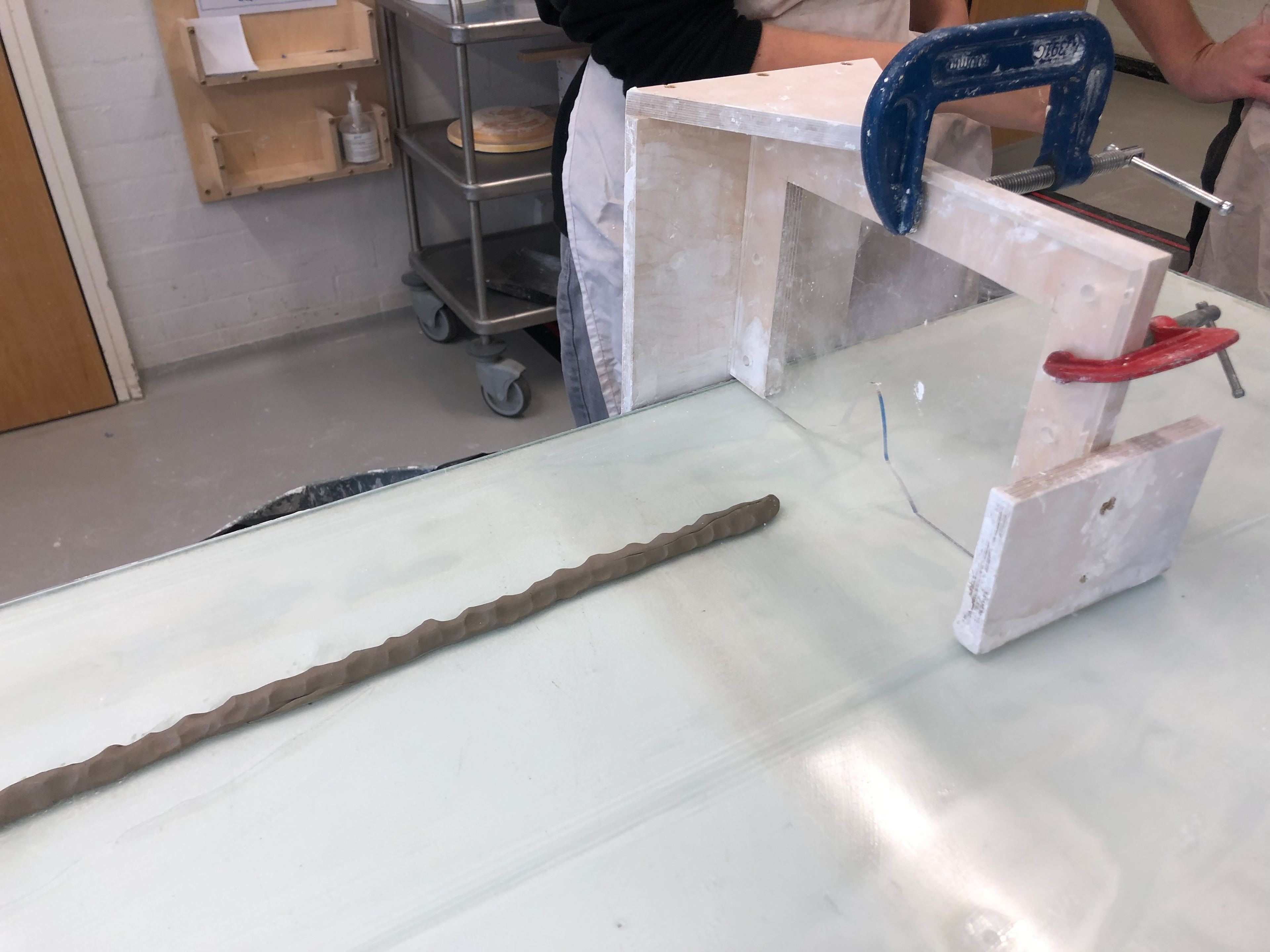 Clay is layed out to allow the plaster to build up. The laser cut piece of acrylic is the desired shape