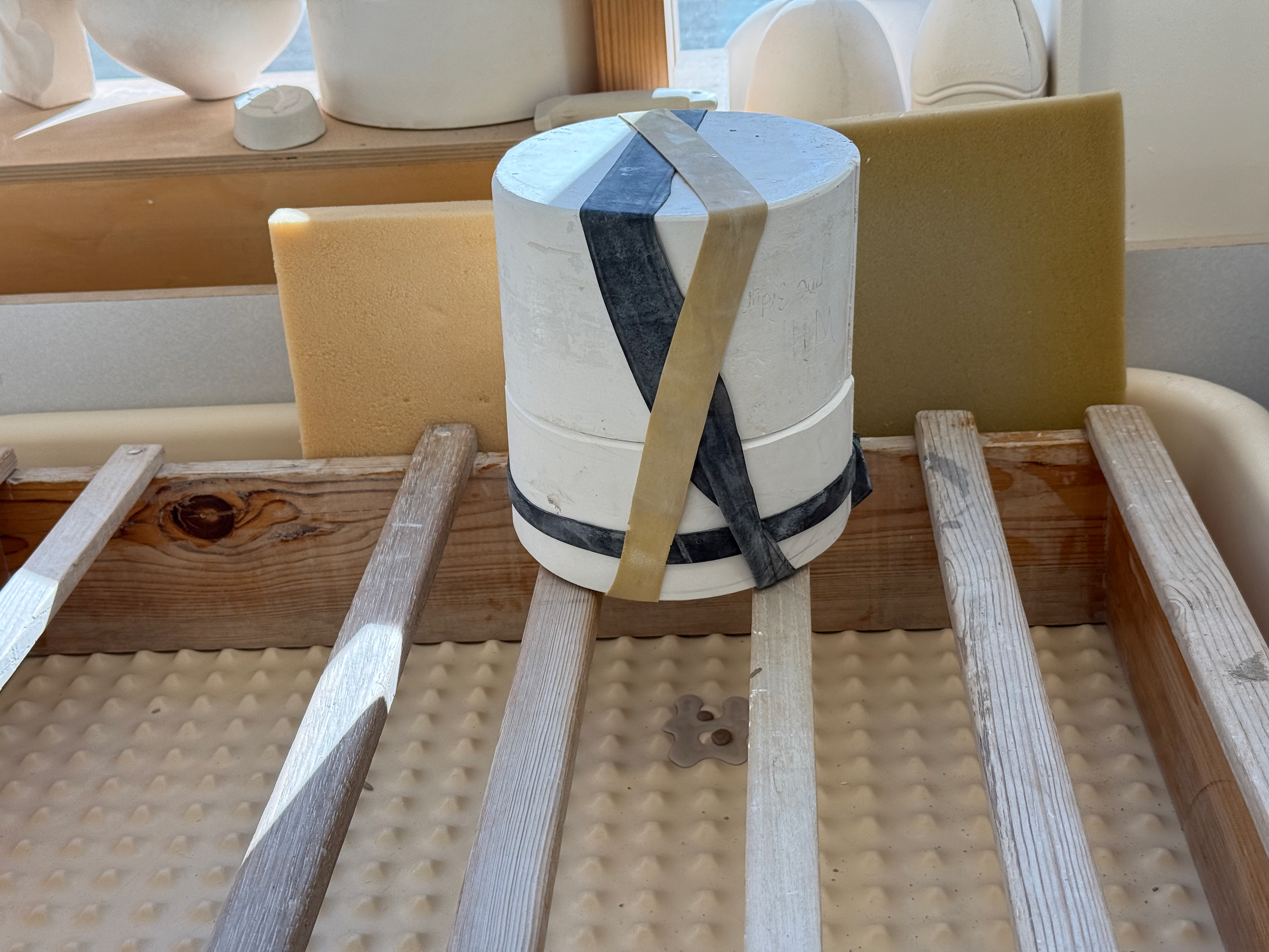 On the slip tray to let it drip and for the plaster to absorb the moisture from the slip.