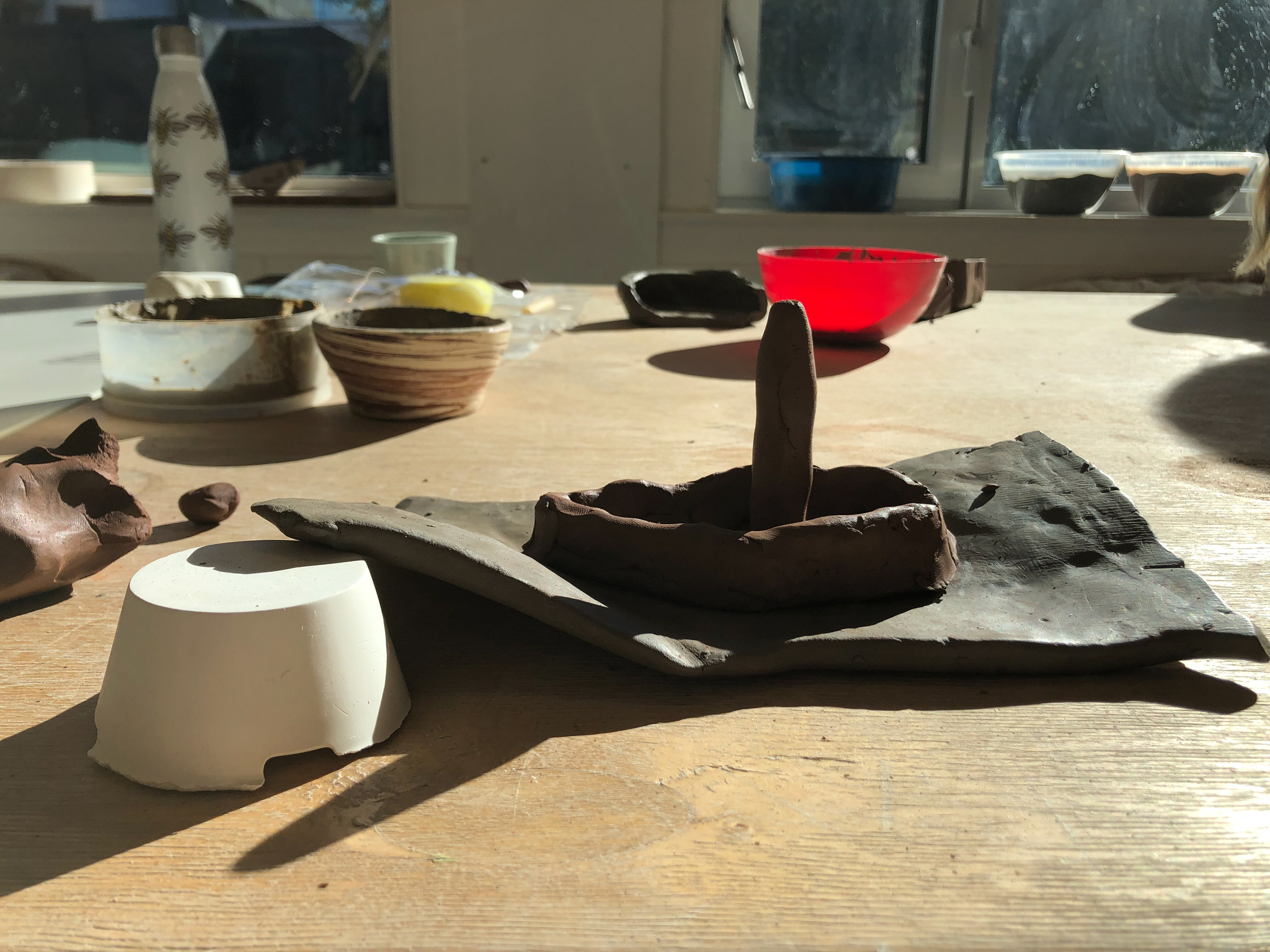I used a plaster block to help retain the flutter shape. I used terracotta to make the boat. I hand rolled two layers of clay and joined them together to create the boat structure and used a final roll for the mast.