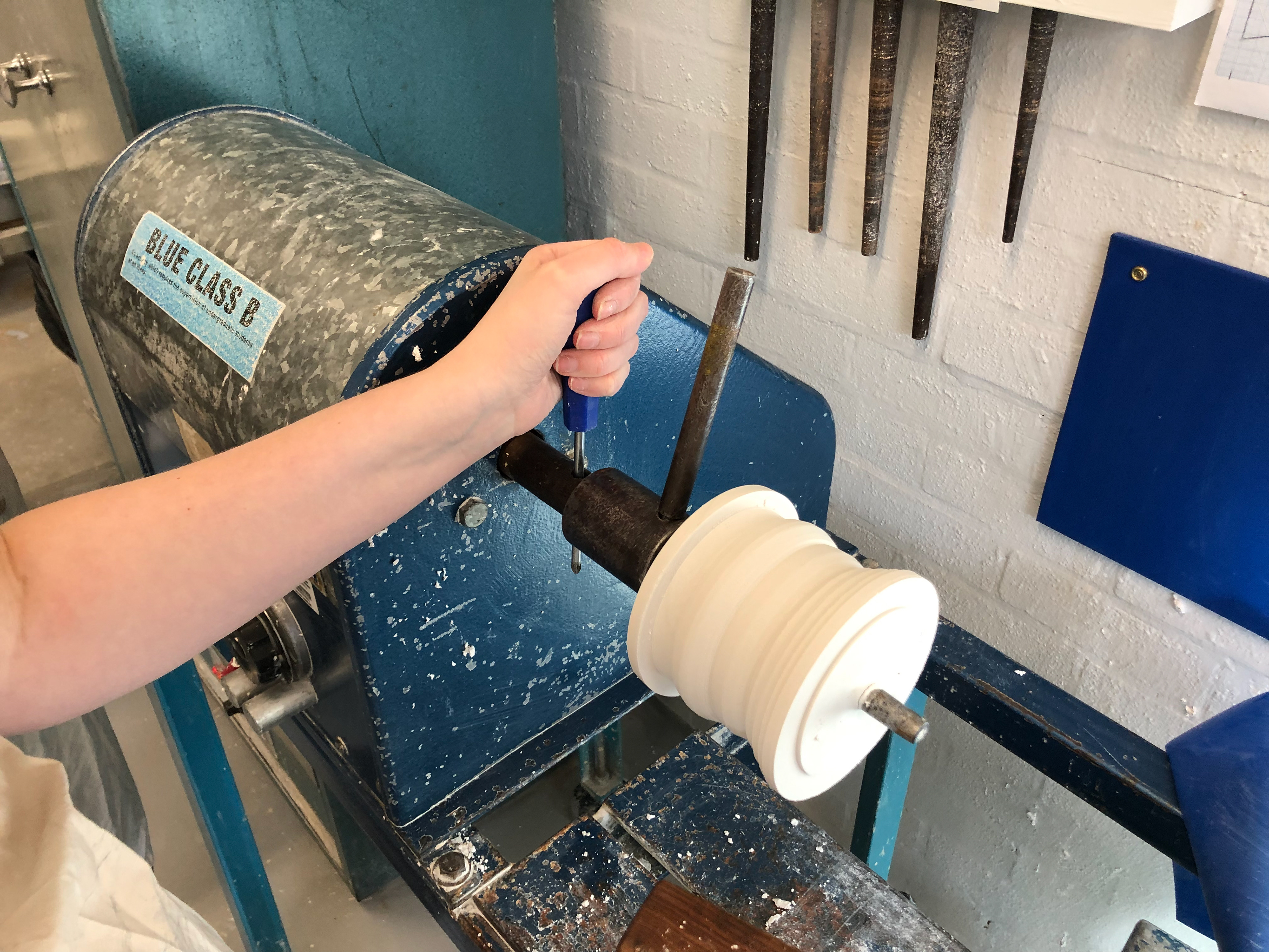 Once you have shaped the plaster as you want. Take a screwdriver and place in one hole and take the metal rod and place it into the other hole.
