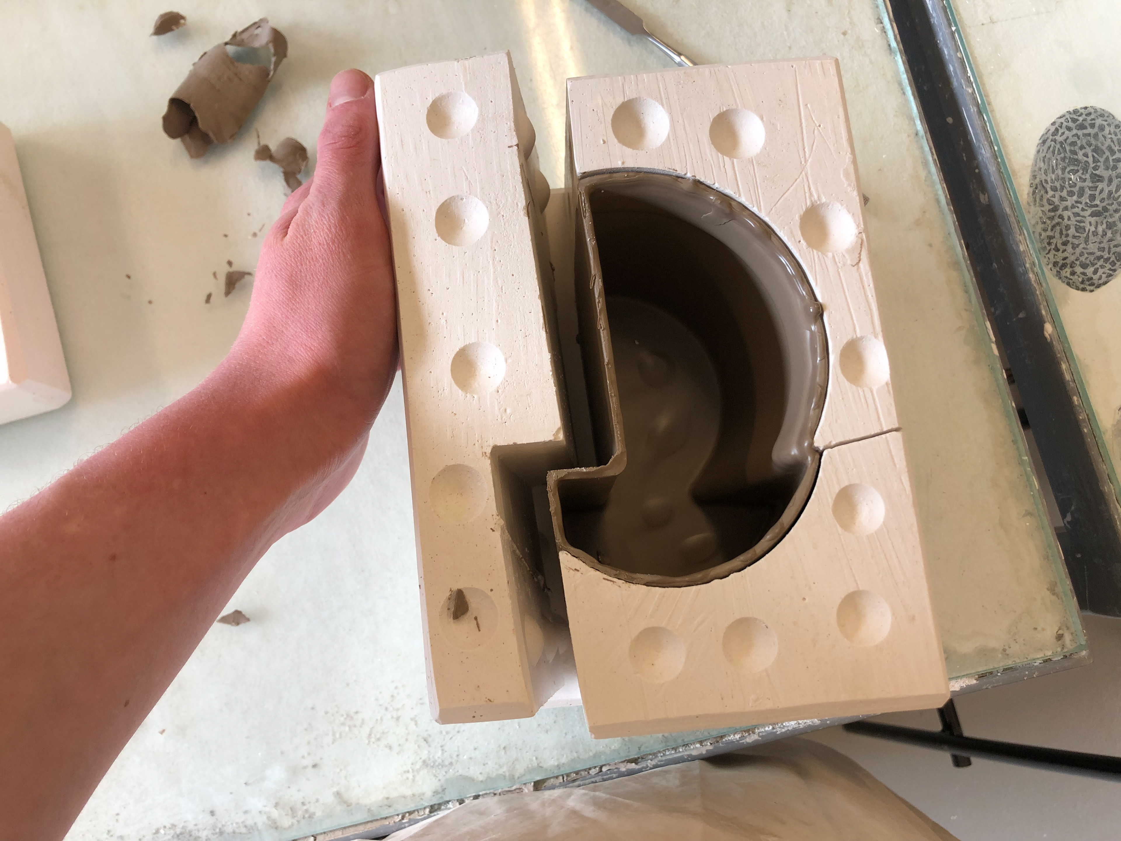 After the remaining slip is poured out and the first part of the mould is removed.