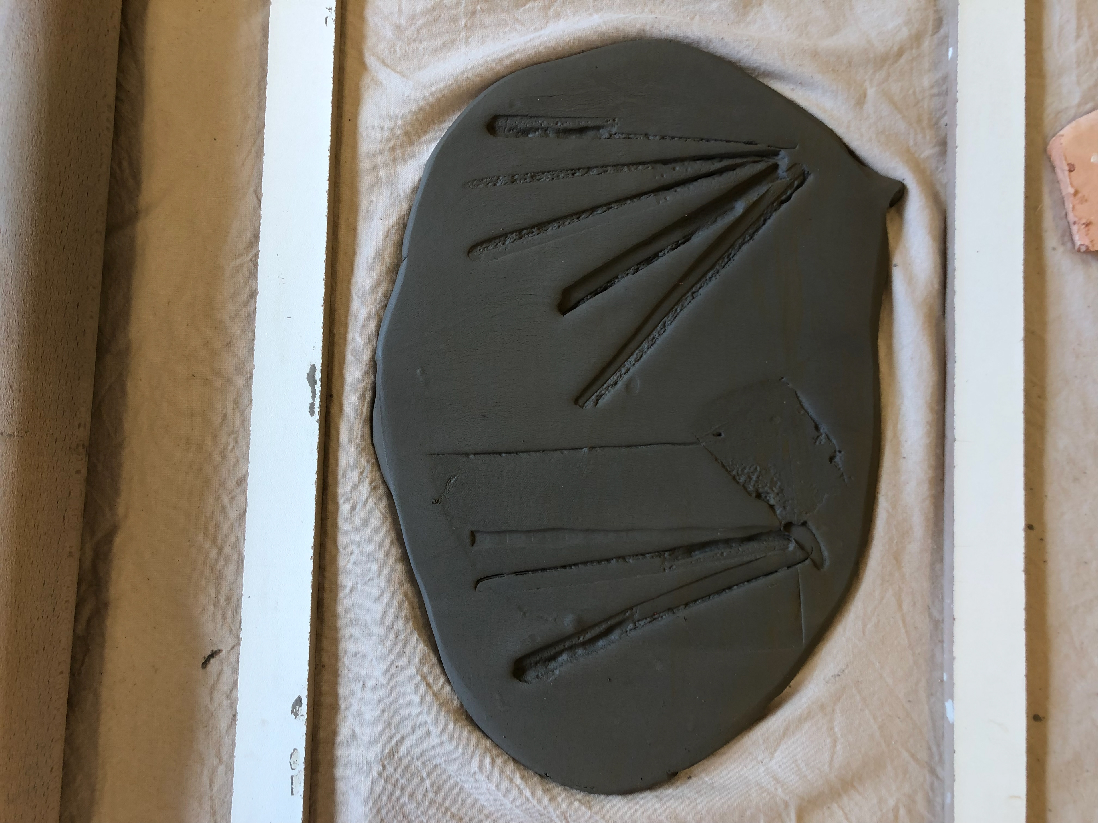 Imprints into clay to mimic pad printing.