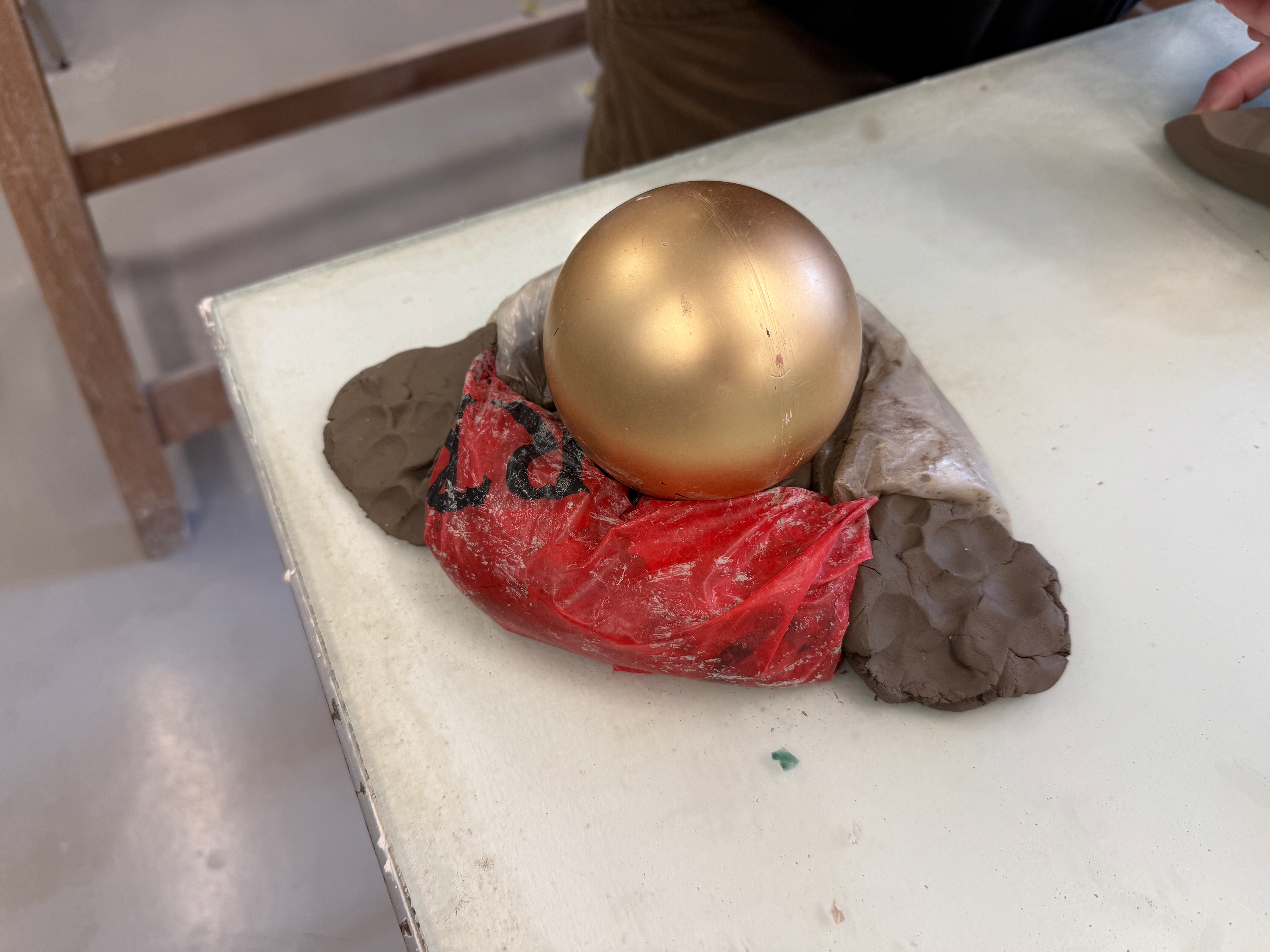 The bauble was placed upside down. This is so the hole was facing down. I then packed clay around it to stop it from moving and to provide a base for the cottle to sit on.