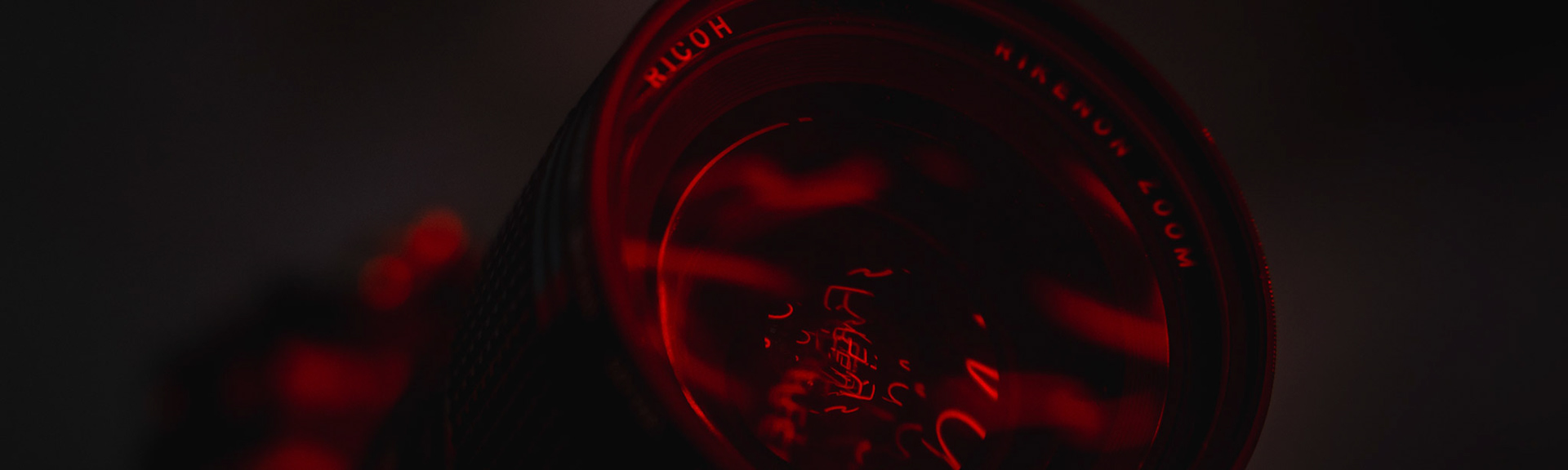 Nahaufnahme einer Fotolinse mit Reflektionen eines Neonschilds