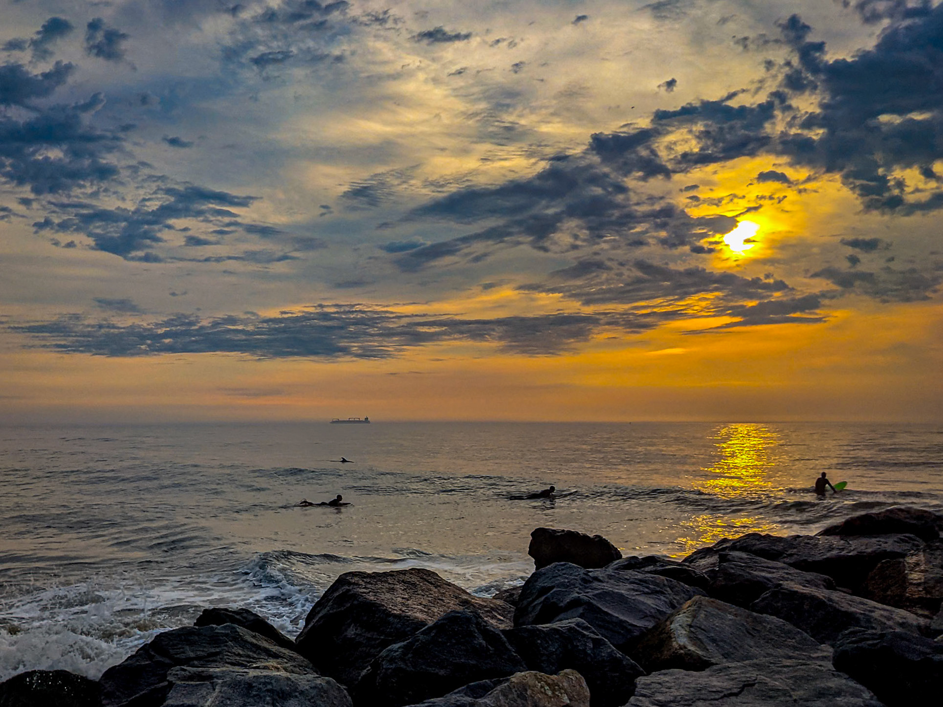 sunrise surfers and a dolphin
