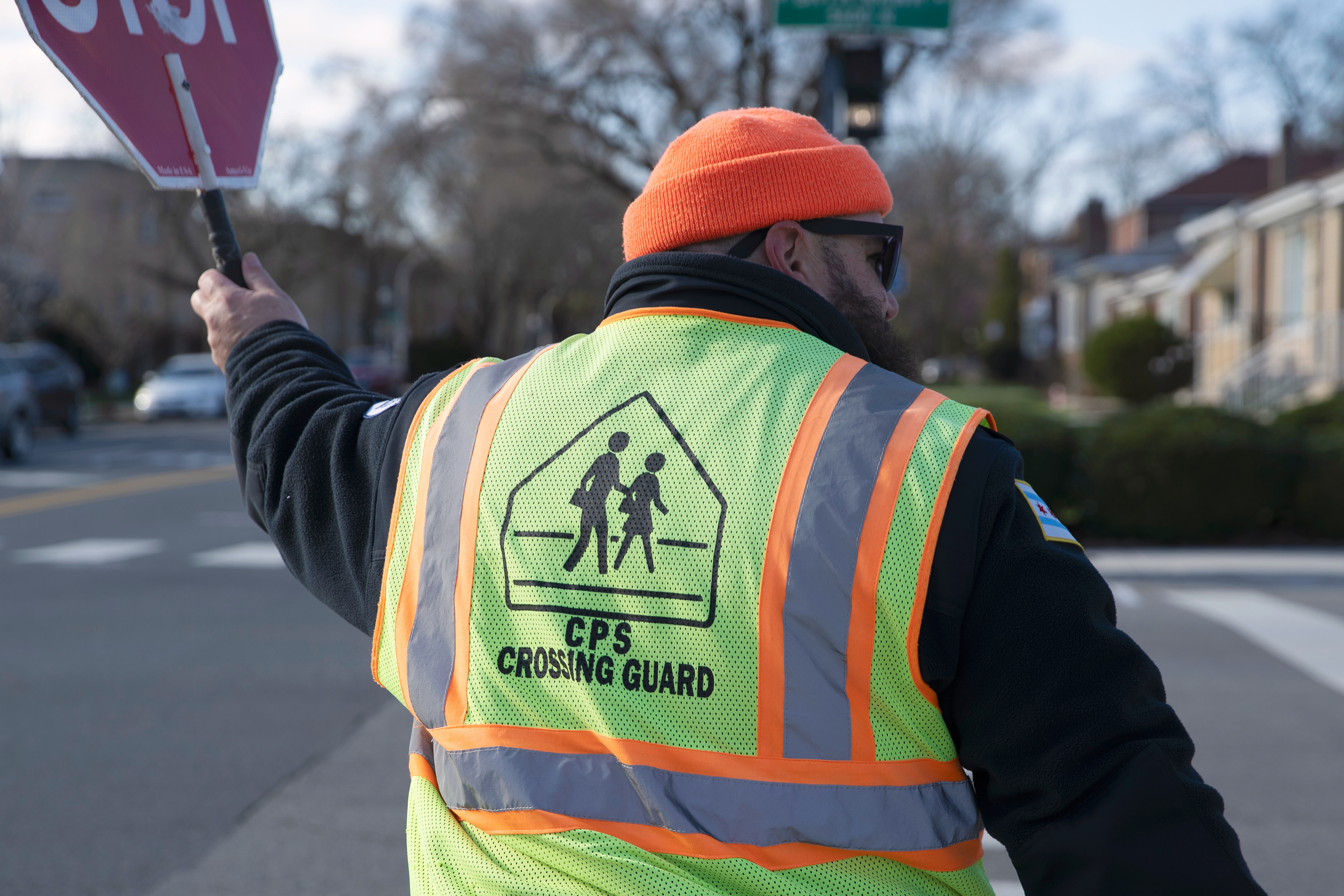 CPS crossing guard Joe Sass  wields a stop sign while escorting pedestrians across West Bryn Mawr Avenue in Chicago on April 7, 2026. Sass communicates with drivers with eye contact and his drivers to ensure safe passage across the street.