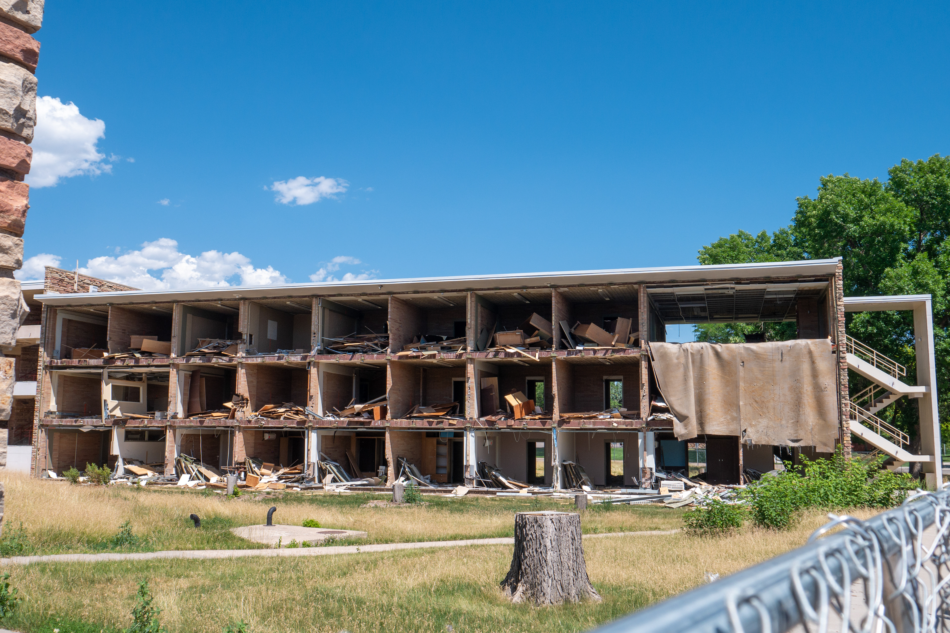 Offices fixtures piled in offices and carpet hanging out of the NE wing, south-facing side
