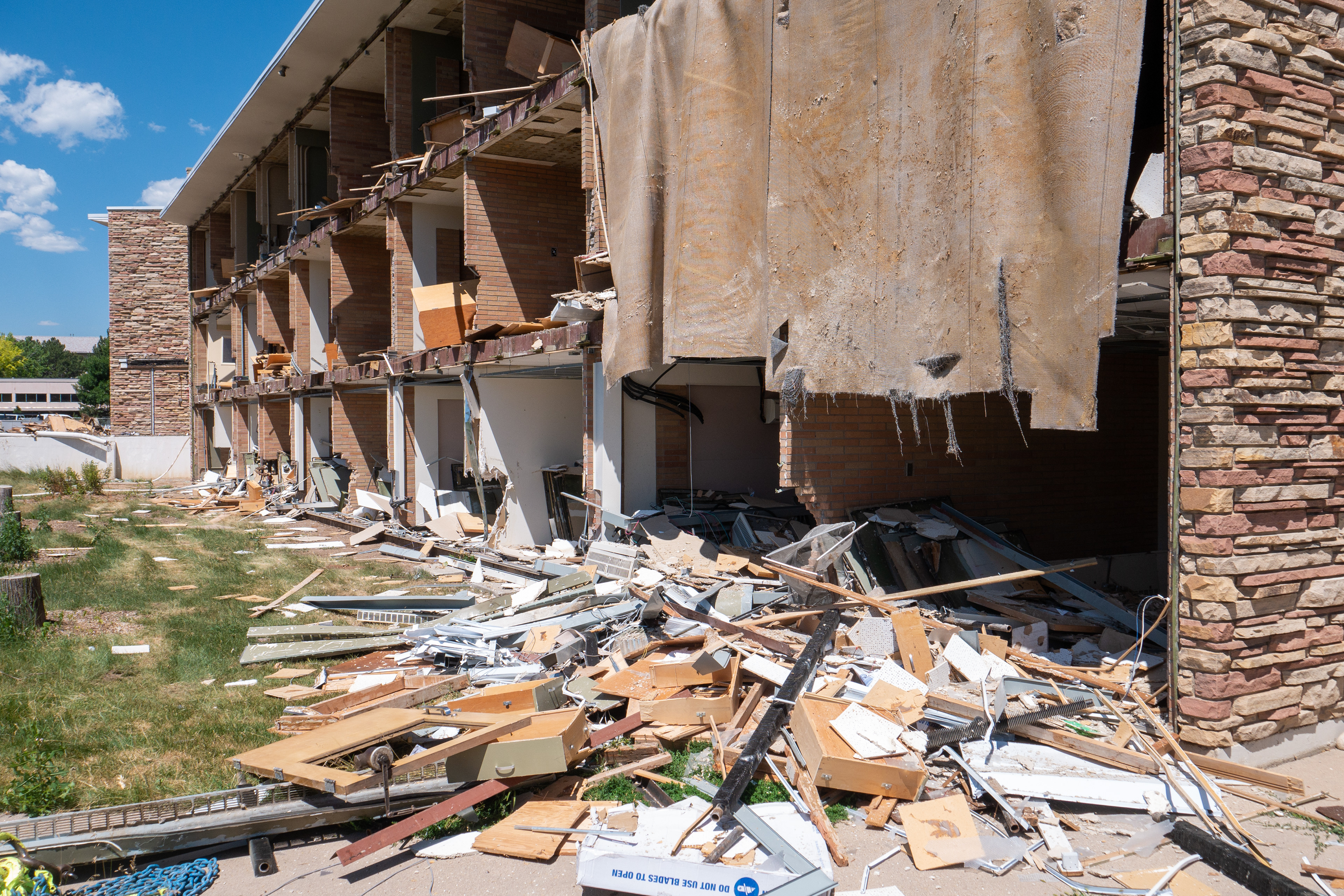 Piles of office debris and carpet hanging from the NE wing, south-facing side