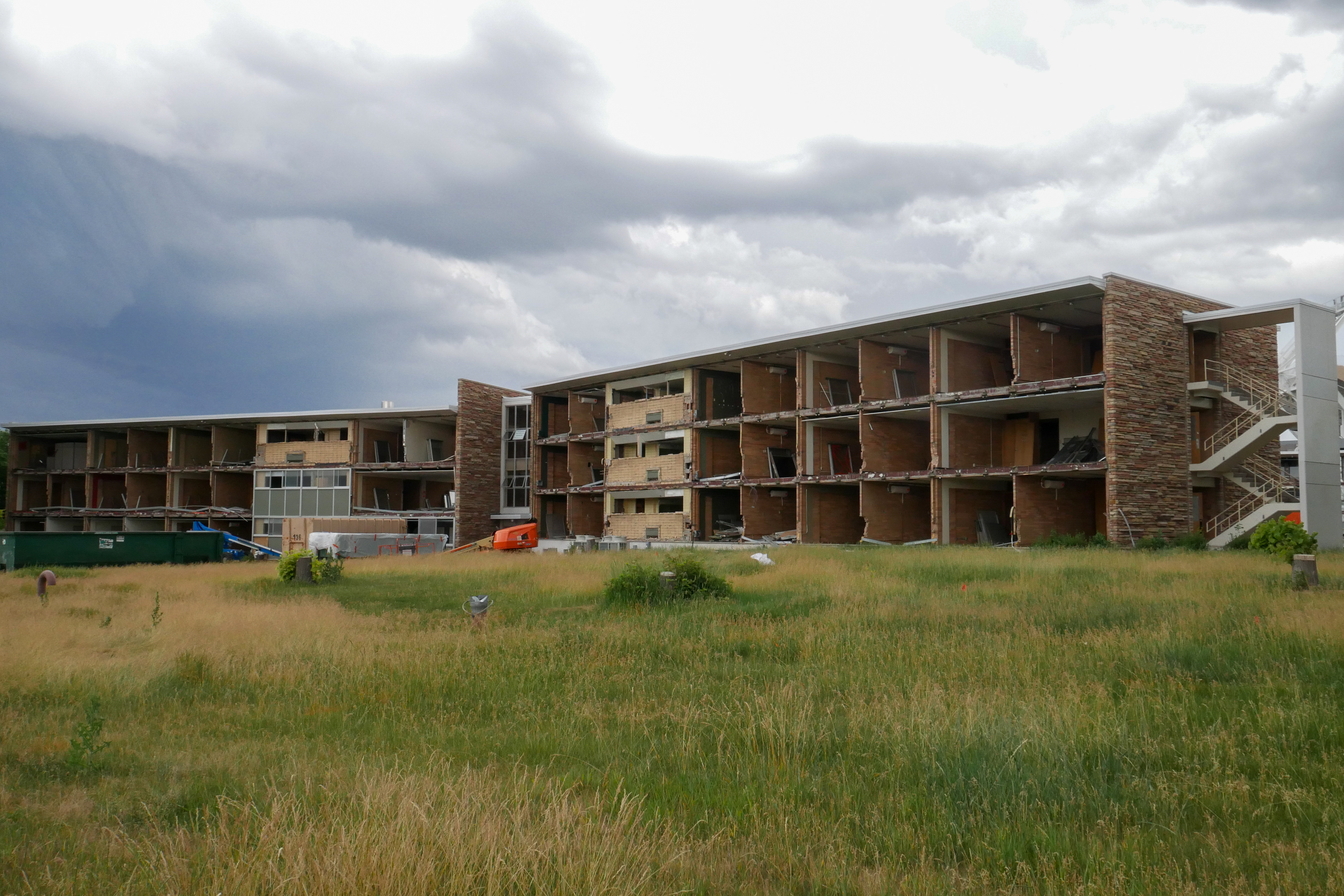 Near full removal of windows and sage green panels, north-facing facade