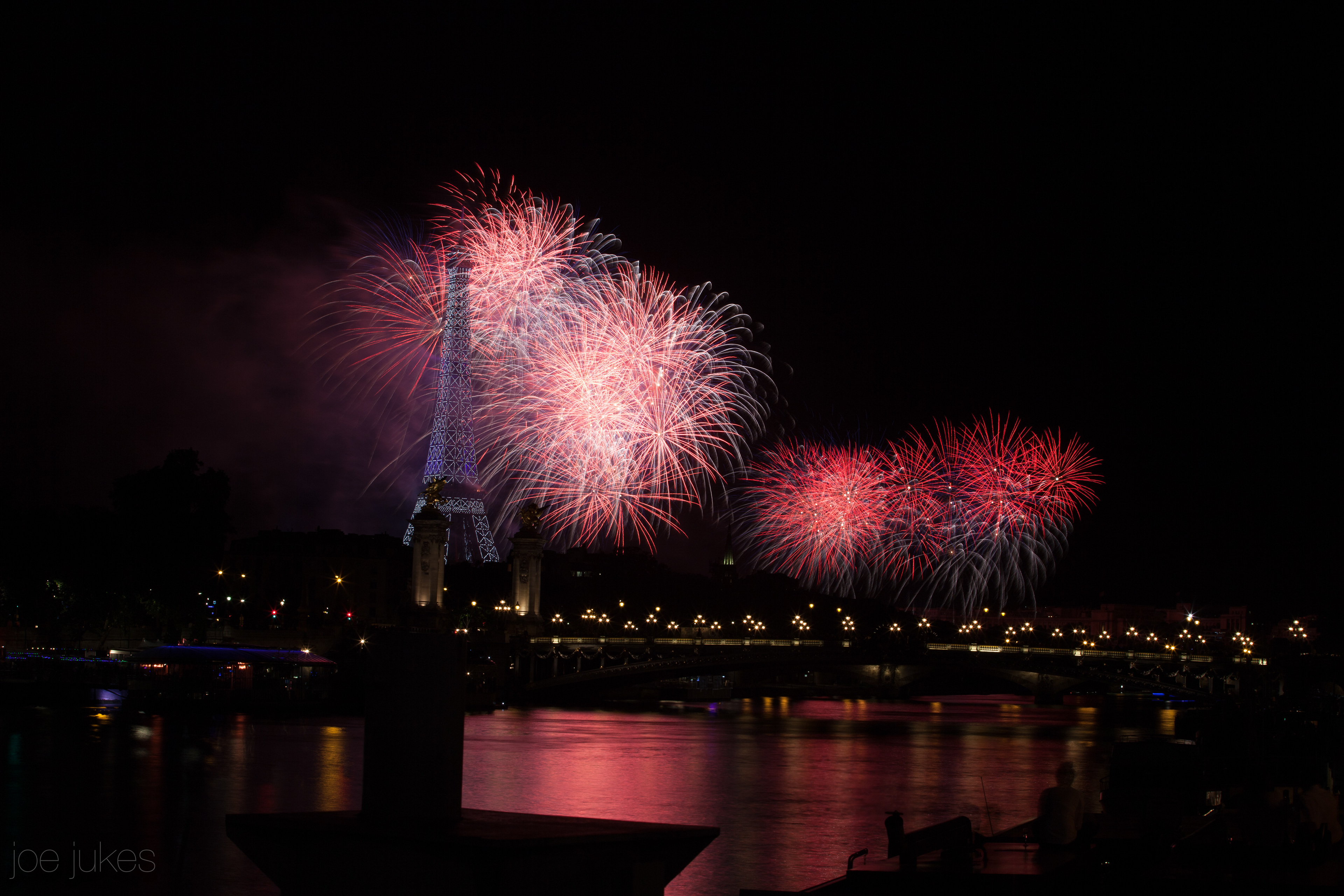 Overlooking the Eiffle Tower and pont Alexandre III from the banks of the River Seine, fireworks on Bastille Day, 14th July - Paris, France
