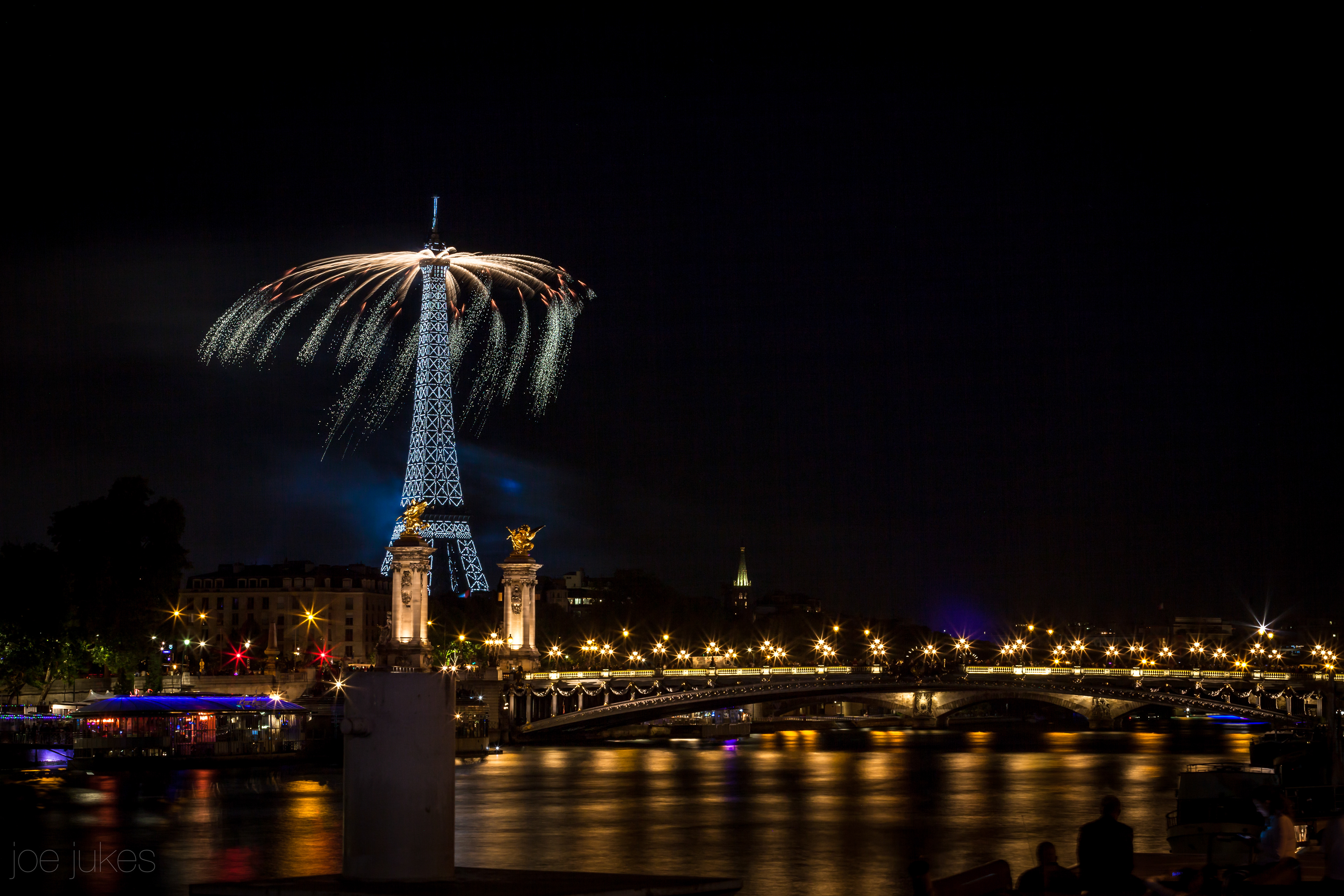 Overlooking the Eiffle Tower and pont Alexandre III from the banks of the River Seine, fireworks on Bastille Day, 14th July - Paris, France