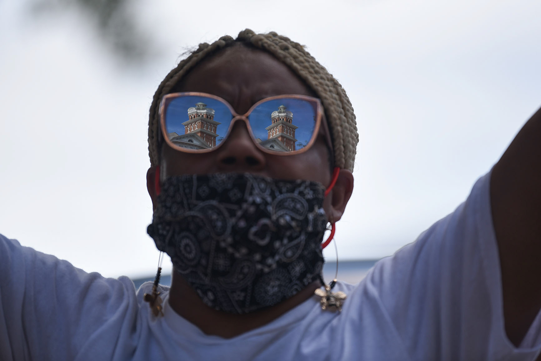 The Lowndes County Courthouse is reflected in Cycelia Matthews’s sunglasses during a Kingdom Vision International Church worship service on Sunday, June 7, 2020. People gathered in front of the courthouse again later in the day for the Jesus and Justice Rally, which was also organized by Kingdom Vision International Church.