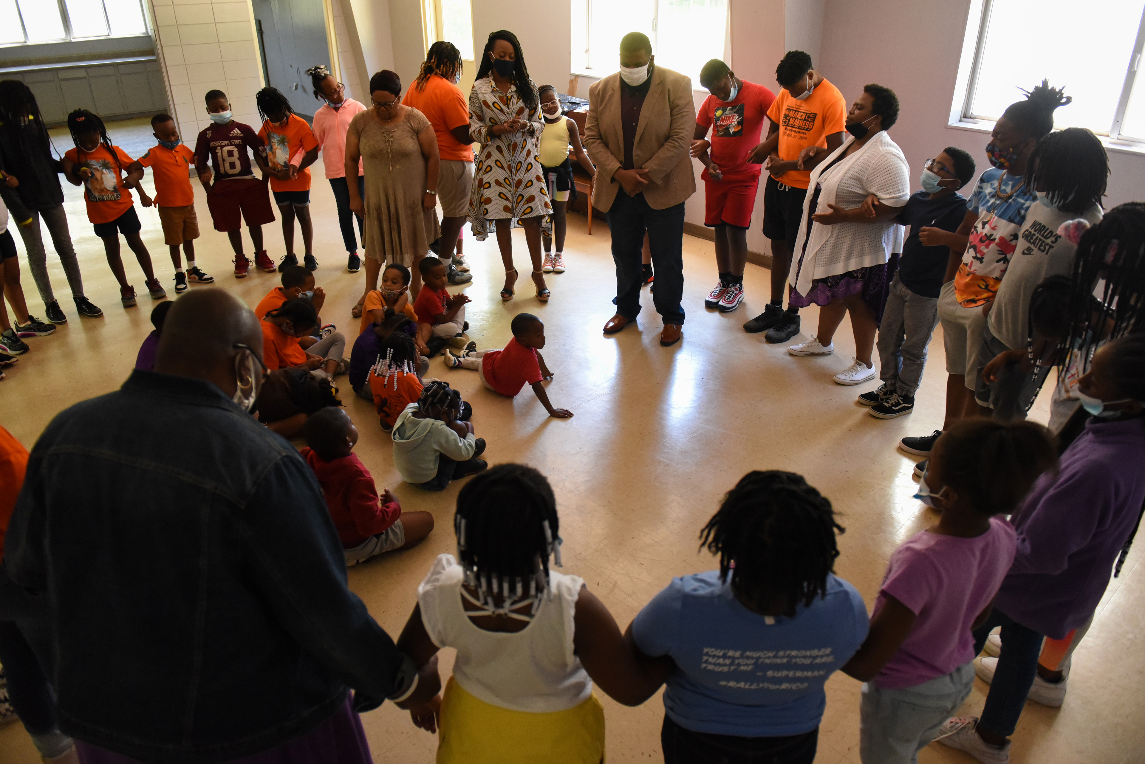 Community leaders, from left, Jackie Rogers, Tammie Tubbs and Jarvis Boyd stand in the middle of a prayer circle during Ms. Smith’s Academic Summer Camp on July 23 at the Needmore Center in Starkville. Before praying, the three led a panel discussion about how to be your best self and have confidence.