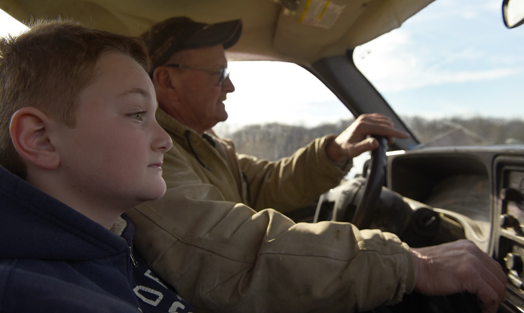 Steve Wehrle and his grandson Tate Wehrle, 10, drive to pick up hay bales to feed their cows Sunday, December 8, 2019 in Rhineland, Missouri. Wehrle’s family owns forty cows, or “just enough to aggravate us,” Wehrle said.