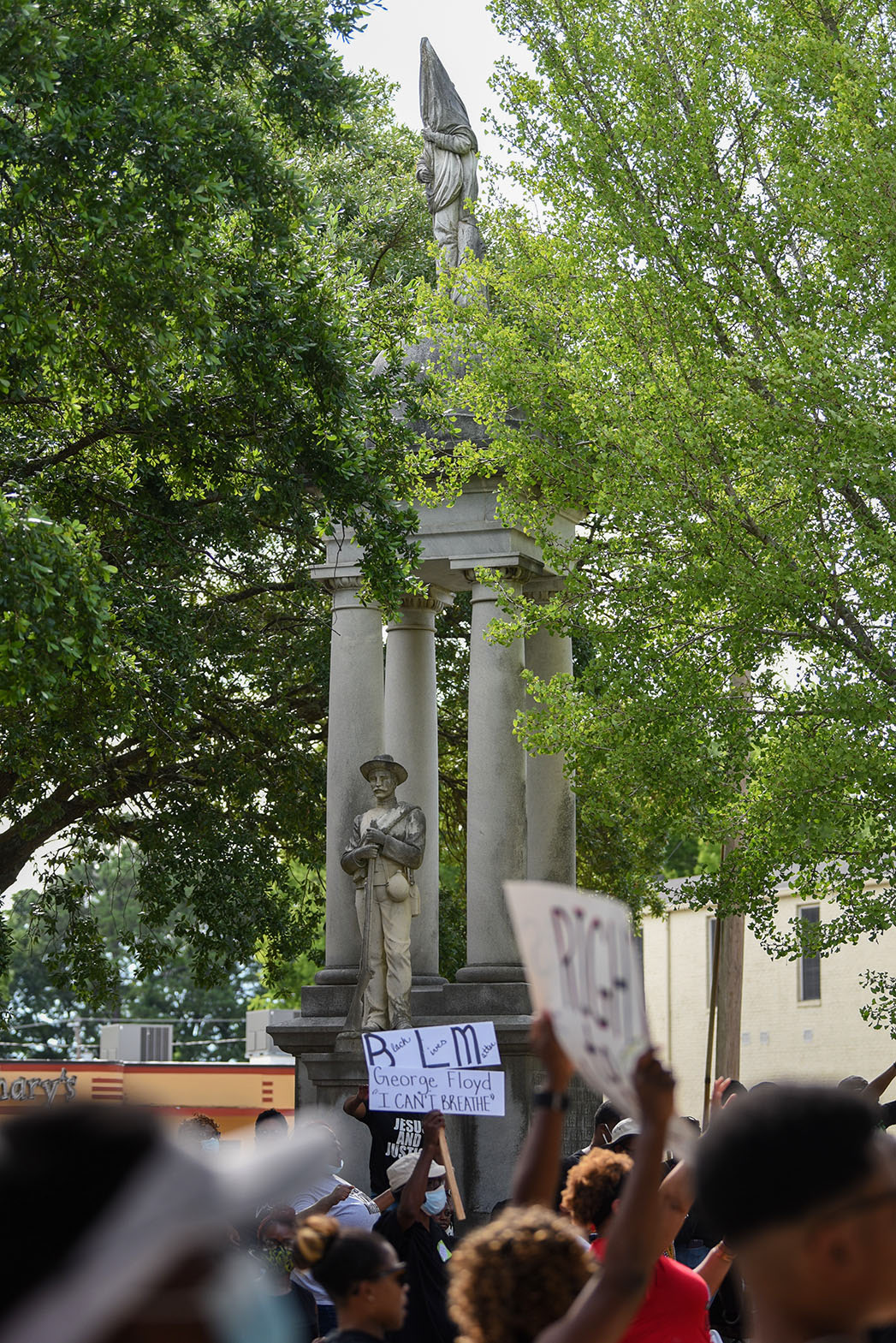 A statue honoring confederate soldiers stands in the background during the Jesus and Justice Rally on Sunday, June 7, 2020 in Columbus. Bishop Scott Volland pointed out the statue when he spoke at the rally, referring to it as “repulsive,” and people cheered loudly in agreement with him.