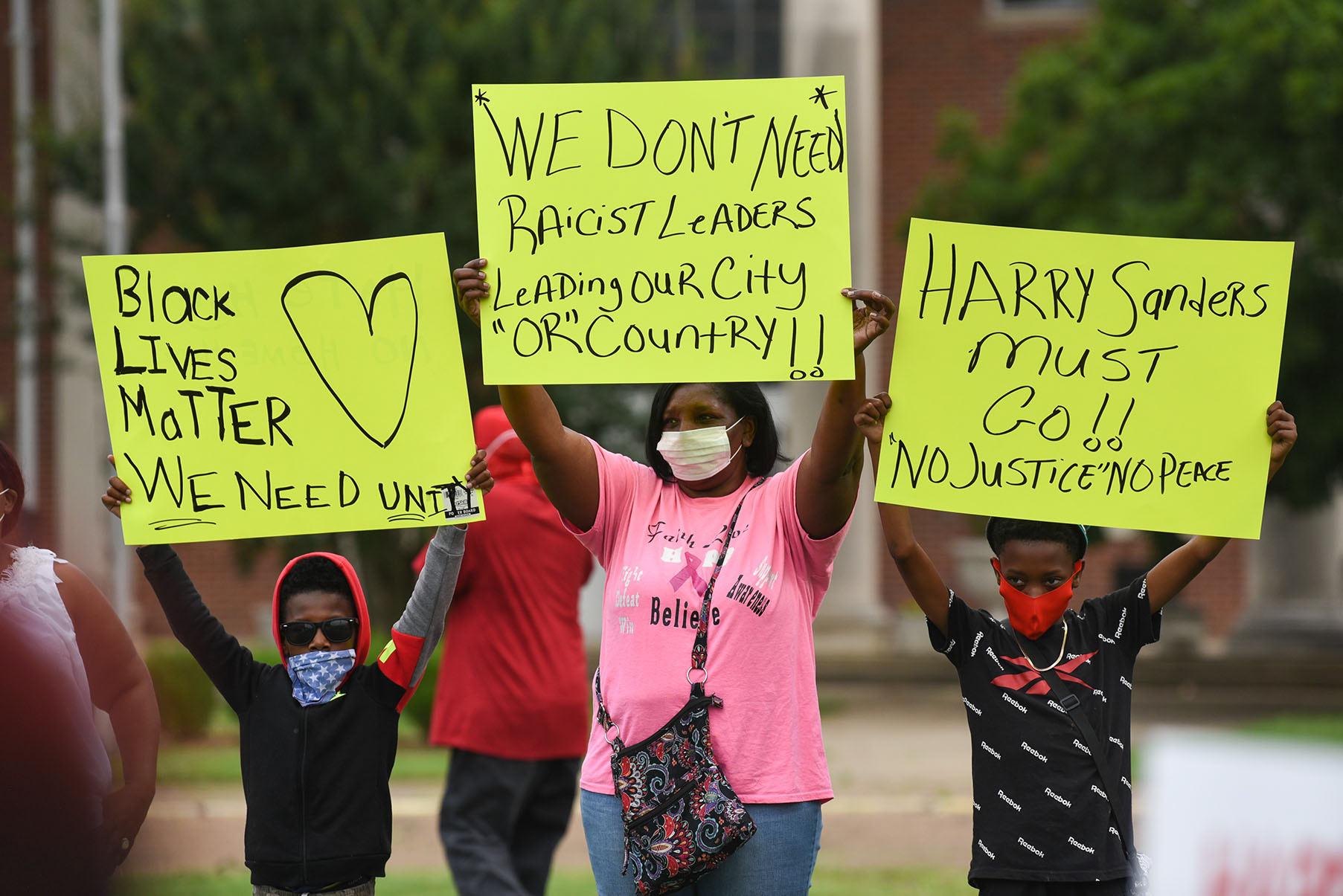 From left, Malachi Turner, 8, Mary Shinn and Demarius Shinn, 10, hold signs during a protest demanding District 1 Supervisor Harry Sanders’s resignation on Tuesday, June 30 outside the Lowndes County Courthouse. The crowd began at the front of the courthouse and then walked to the back entrance that the county supervisors use.