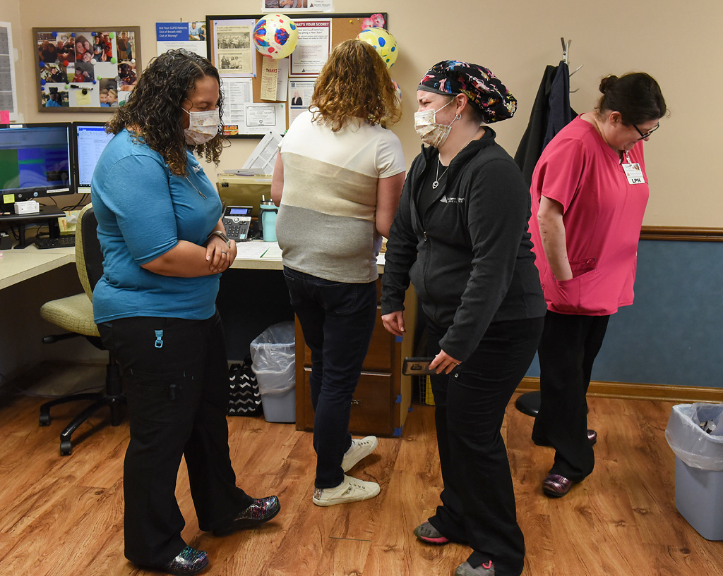 From left, Sarah Kirchhoff, Kim Harrington, Jacki Addington and Ciaira Cain laugh about an online video on Tuesday, April 28, 2020 at the Western Missouri Family Healthcare clinic in Concordia. Addington laughed and said that most clinics don’t have as much fun as they do. Later in the day, Kirchhoff treated her staff to smoked meatloaf from Dempsey’s BBQ, one of Concordia’s local restaurants.