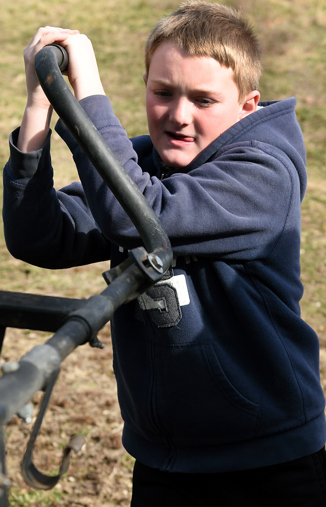 Tate Wehrle, 10, cranks a lever to attach a trailer to a truck Sunday, December 8, 2019 in Rhineland, Missouri. Tate helps on the farm almost every day and has learned the ropes by observing his grandfather and dad.