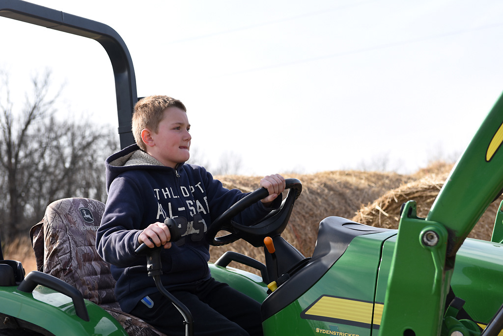 Tate Wehrle, 10, drives a tractor to move hay bales Sunday, December 8, 2019 in Rhineland, Missouri. Tate learned how to drive the tractor when he was eight years old and maneuvers the hay bales with confidence and ease.