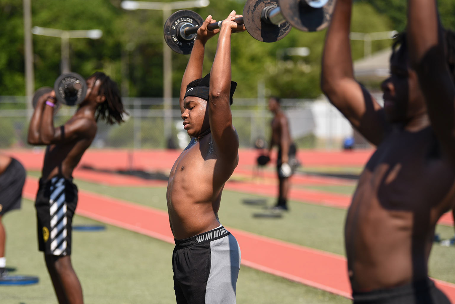 Senior Blake Williams lifts weights above his head during football practice on Thursday at Starkville High School. Coaches disinfected the weights between each rotation of players as a precaution for COVID-19.