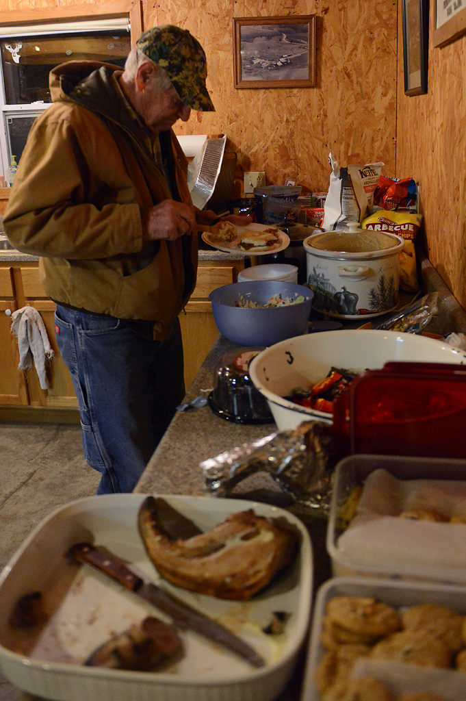 “Uncle” Ed Bruckerhoff helps himself to dinner during deer camp Friday, November 15, 2019 in Rhineland, Missouri. Everyone brought dishes to share like sloppy joes, pulled pork, cole slaw, cookies and chips.