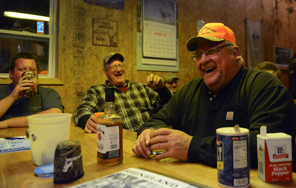 From left, Shad Noltensmeyer, Tom Bruckerhoff and Kevin Hagedorn, or “Kernel Hagenbauker” laugh and drink whiskey during deer camp Friday, November 15, 2019 in Rhineland, Missouri. Everyone sat around tables in The Shack for a few hours exchanging stories, making jokes and poking fun at each other, and recounting fond memories from previous deer camps.