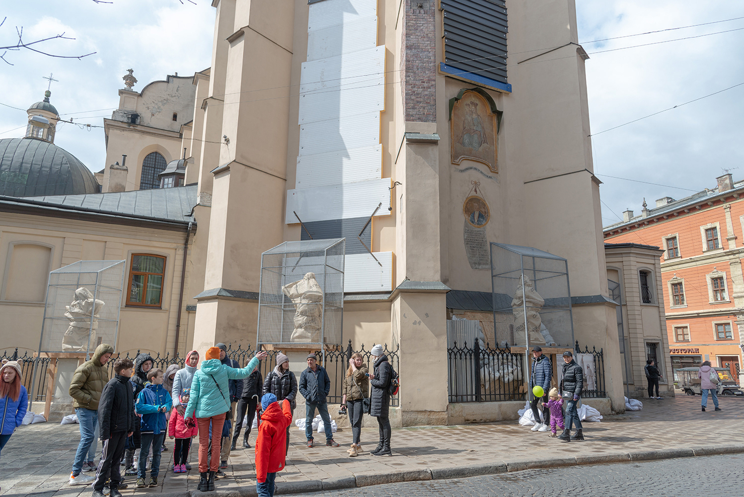 A guide conducts a tour in the old part of the city, which is included in the UNESCO World Heritage Site, for a group of tourists - internally displaced persons, mainly from the central and eastern regions of the country. The local authorities of the city of Lviv have taken measures to preserve cultural heritage.