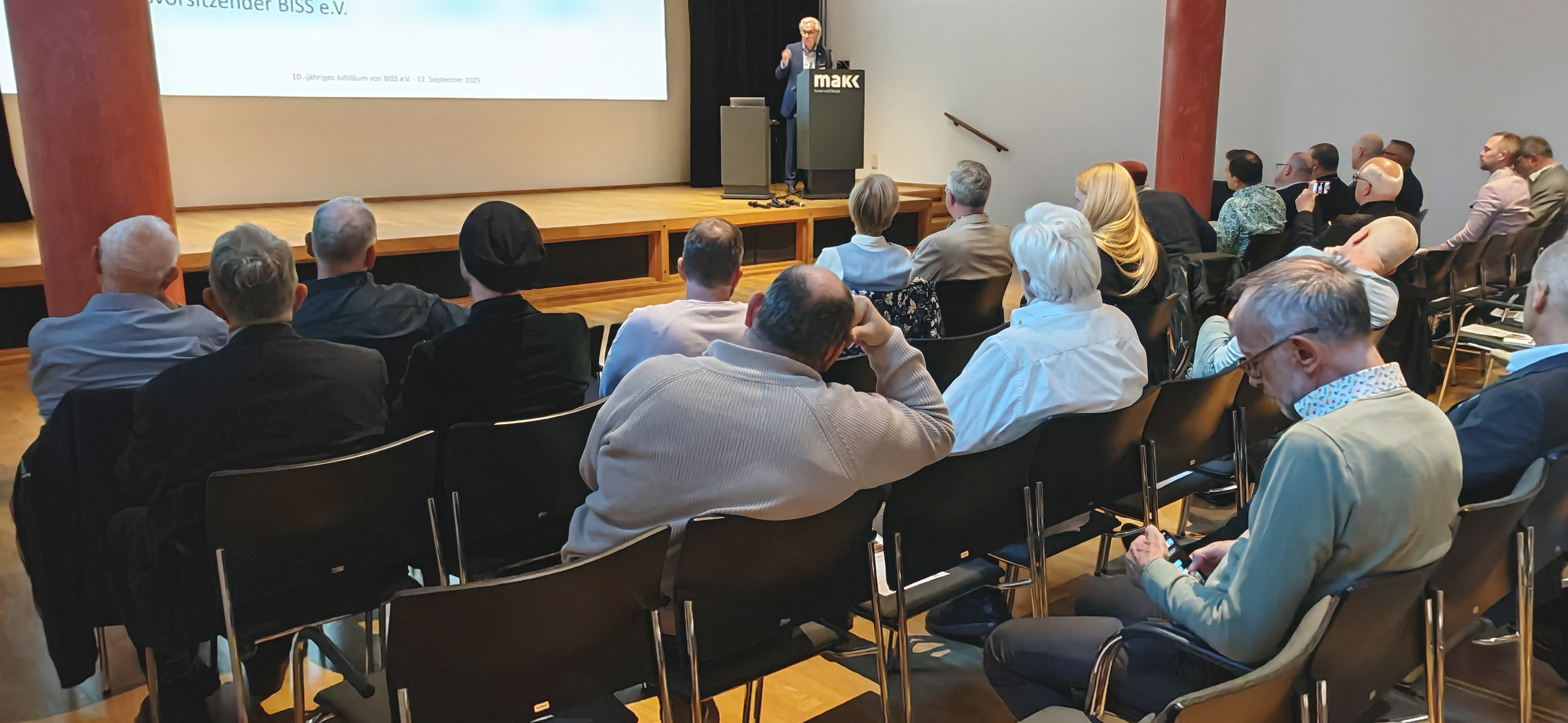 Das Publikum verfolgt interessiert die Rede von Wolfgang Schwarz-Heim bei der BISS-Jubiläumsfeier. 