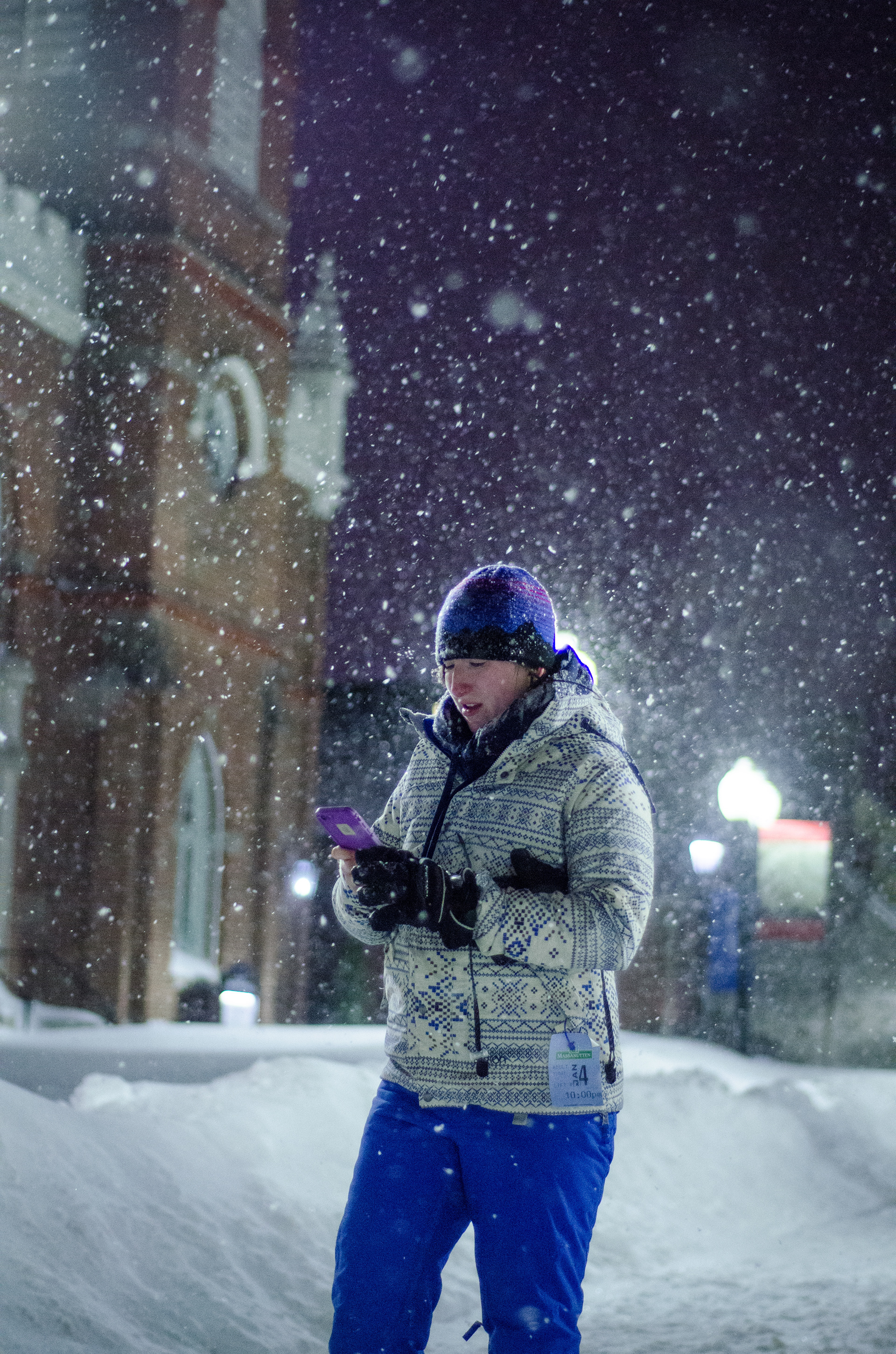 Kayla Green checks her phone during a snowstorm in Winchester, Virginia