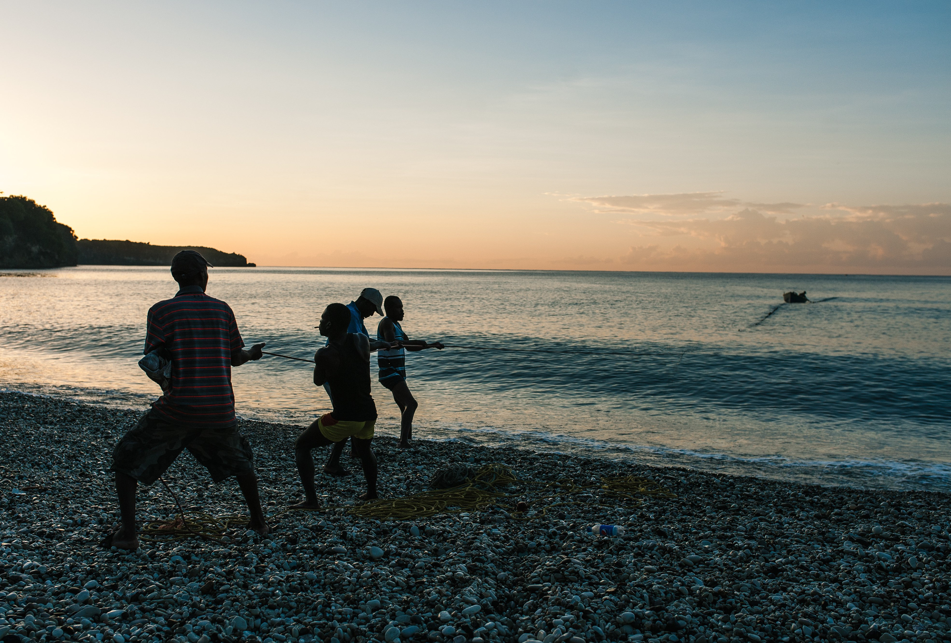 At dawn, men take out nets on the main beach at Bainet, a small town on Haiti’s southern coast. The net was led out in a semi circle by a man in a small paddle boat, while two teams of four men gradually pull the net in. Fishing is a significant part of the economy in this region, though there are few motorized boats or equipment. // OCTOBER 23, 2018, BAINET, HAITI