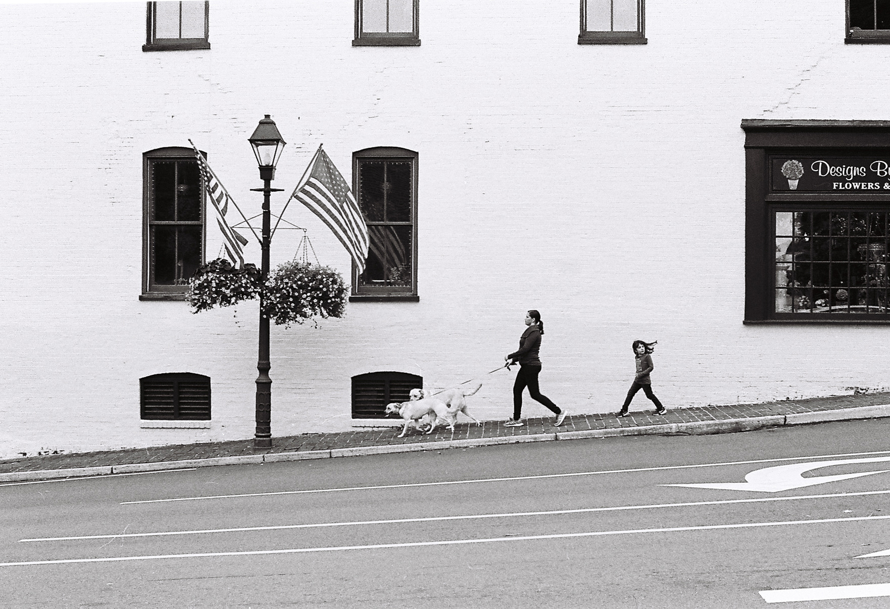 A woman walks her dogs down Alexandria Pike in Warrenton, Virginia
