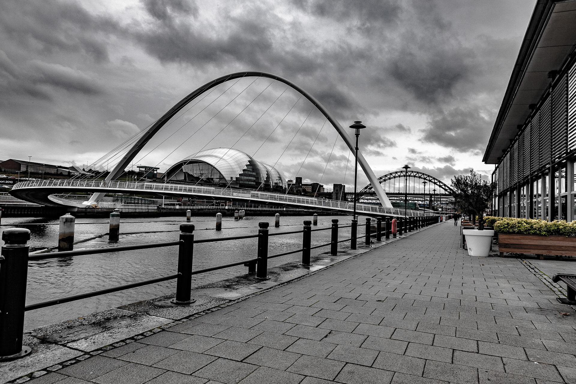 Stud on the quayside looking at The Millennium Bridge, The Sage and The Tyne Bridge beyond