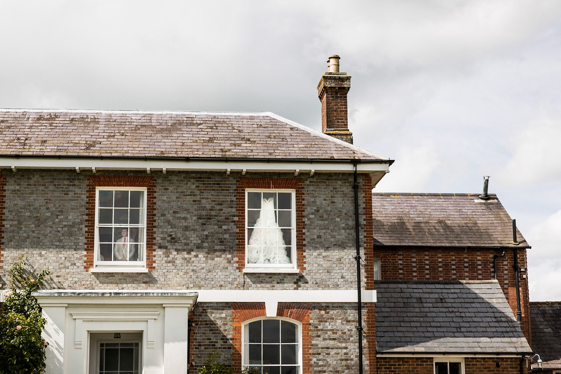 The bride and groom are getting ready to head to the church in Ripe, England.  I was outside the farm house, taking a few details when I looked up to see the groom looking out the window while his beautiful bride readied herself in the room next door.
