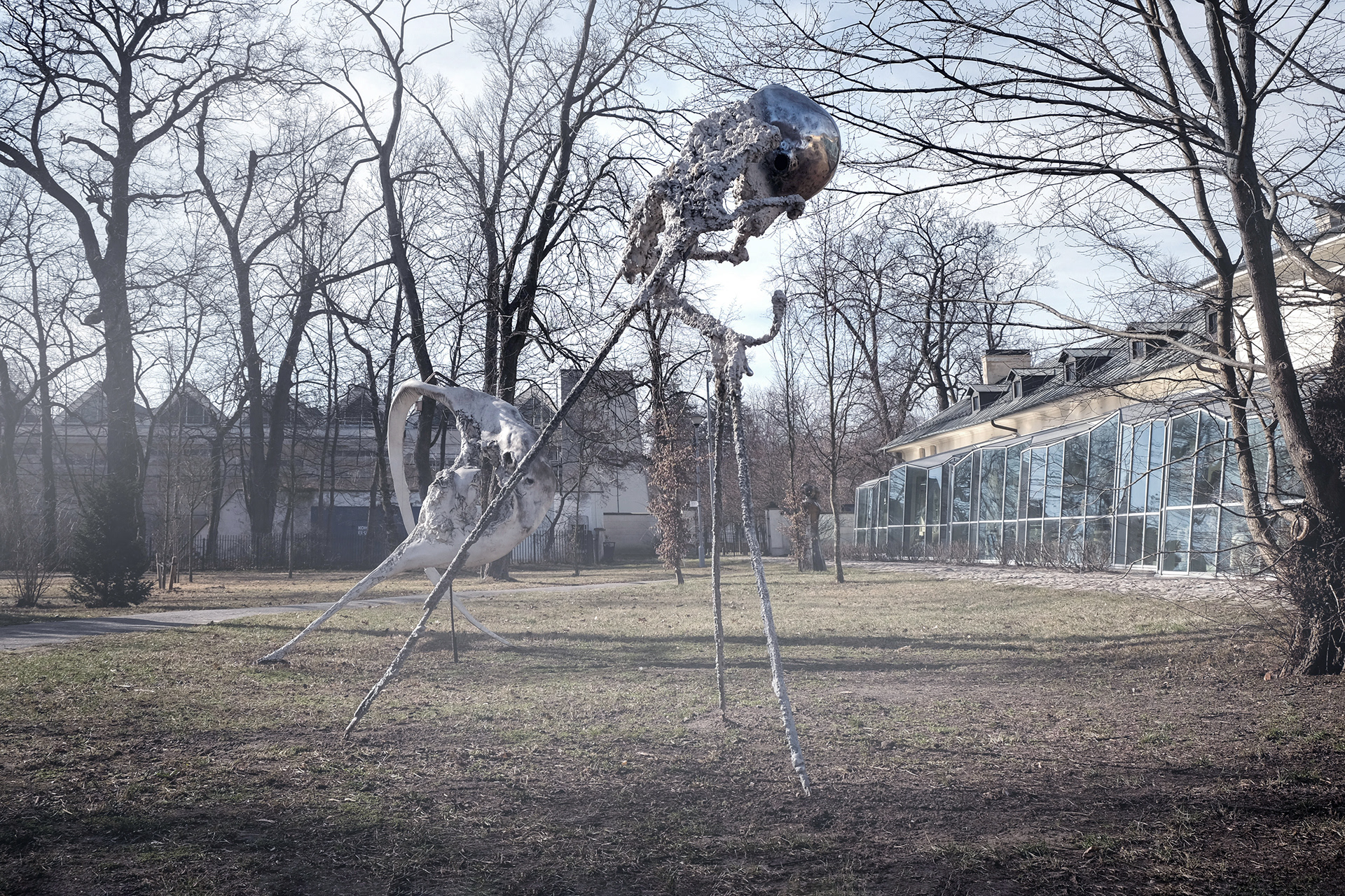 Large-scale sculpture from the Non–Humans series by Jan Gostyński, cast in bronze and aluminum with structural steel elements. The work takes the form of a hybrid, biomorphic figure with an irregular, expanding surface that evokes both organic growth and eroded matter. Shown outdoors at the Museum of King Jan III’s Palace at Wilanów, the sculpture stands in visual dialogue with the surrounding historical architecture and landscaped gardens, emphasizing the contrast between its contemporary, fragmented form and the classical setting.