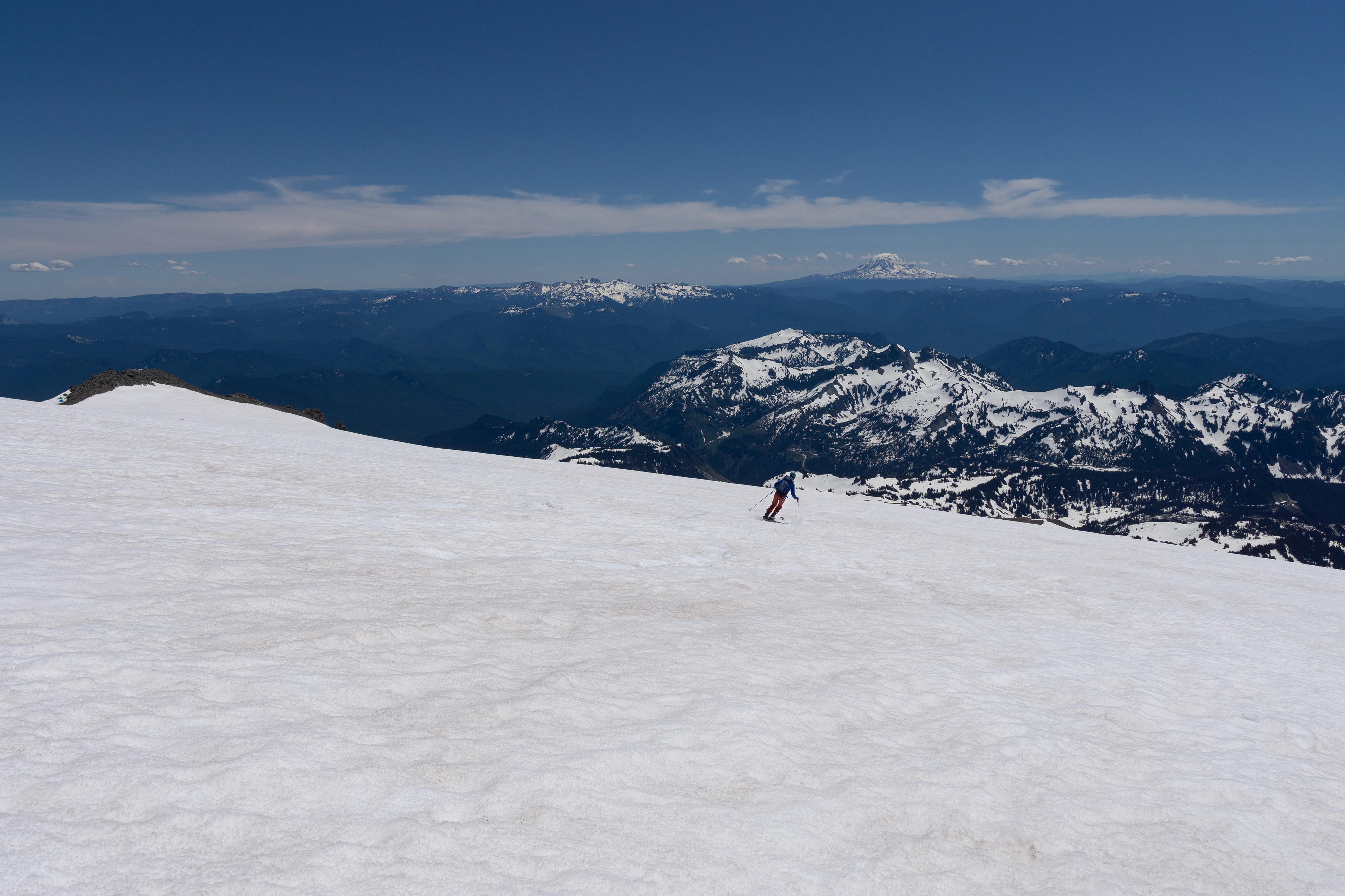 Forrest skiing Mt. Rainier with Mt. Adams & Mt. Hood in distance