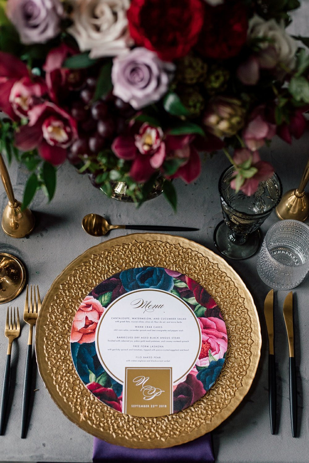 Textured gold charger plates create a stunning backdrop for the bold floral Menu that rests on top