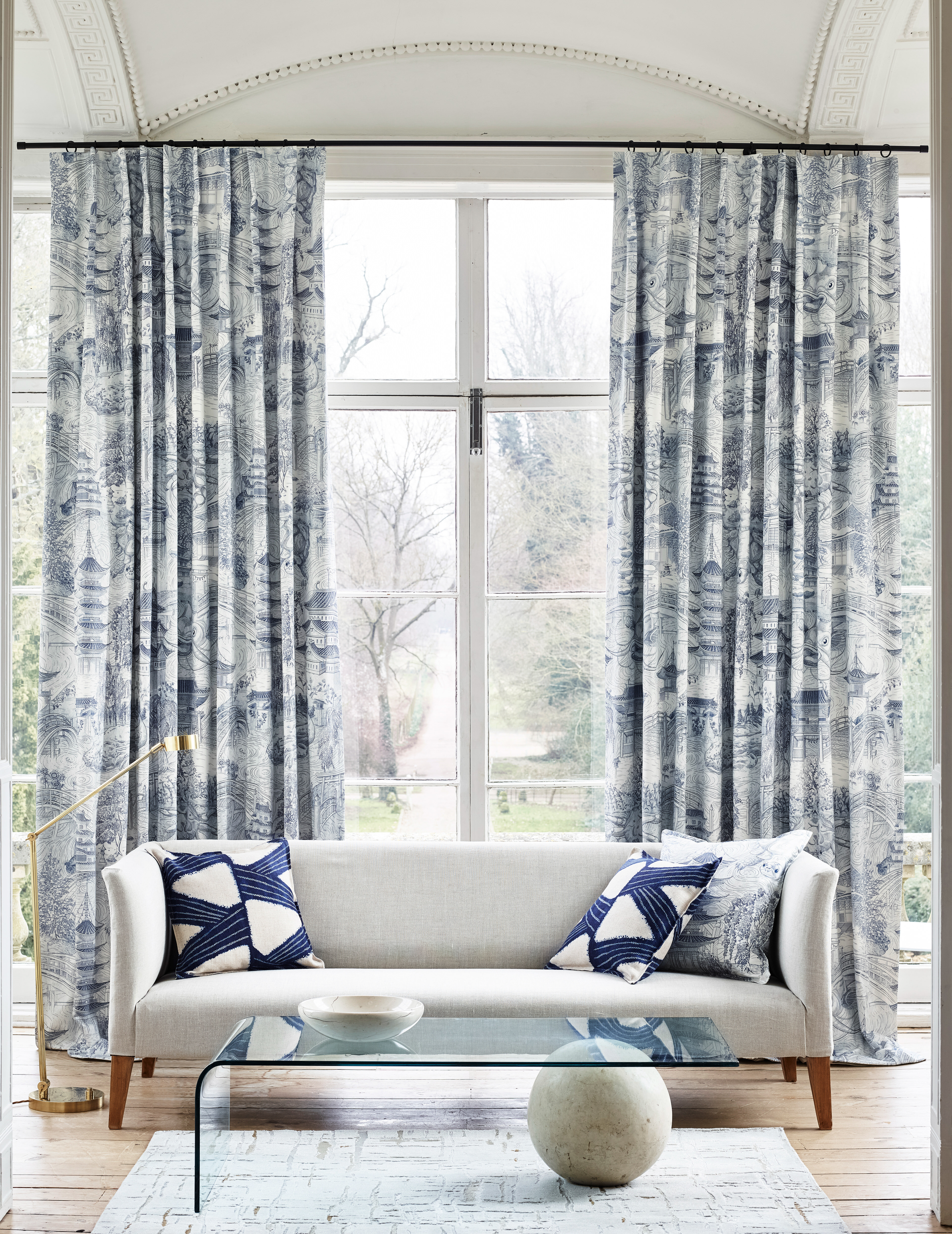 Huge windows in a beautiful stately home featuring draped curtains with the Eastern Palace pattern from Zoffany.