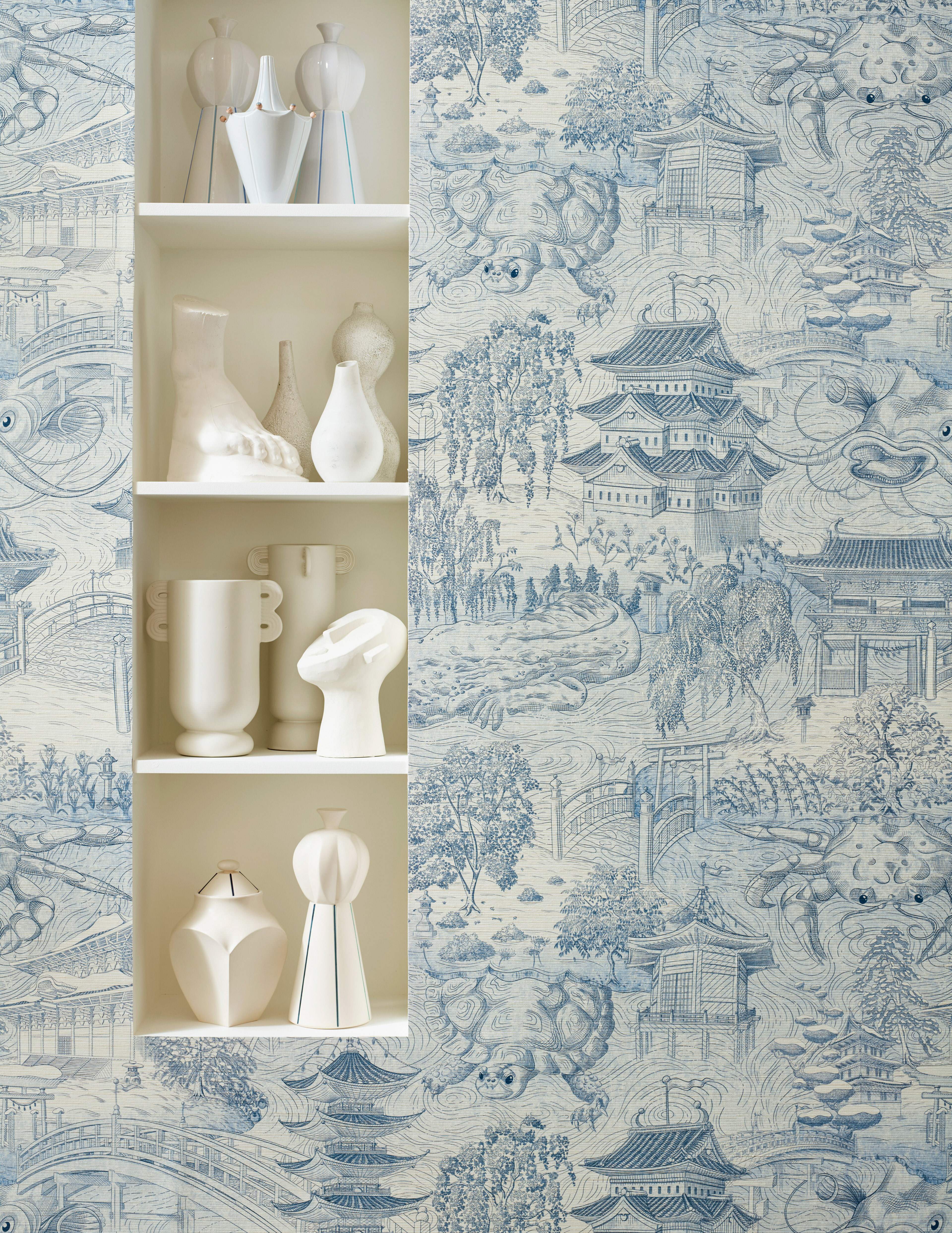 Close-up shot of the Eastern Palace wallpaper from Zoffany next to white ornaments on shelves.