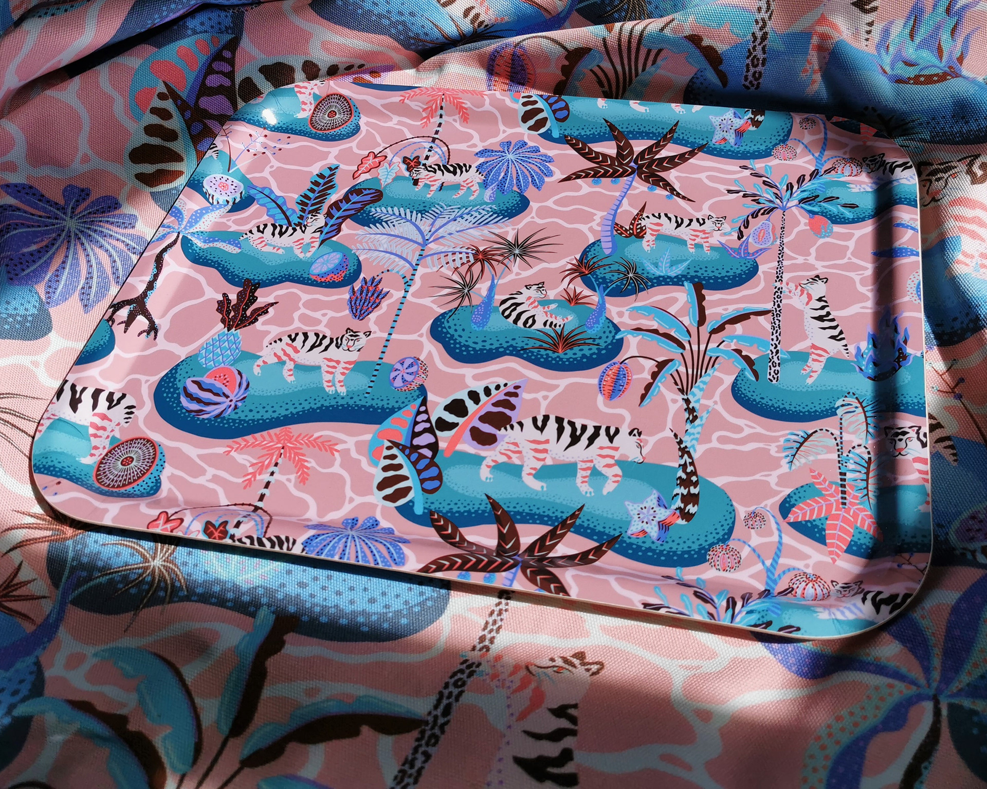 Product shot of millennial pink tray showing a tropical ocean pattern featuring tigers and islands. 
