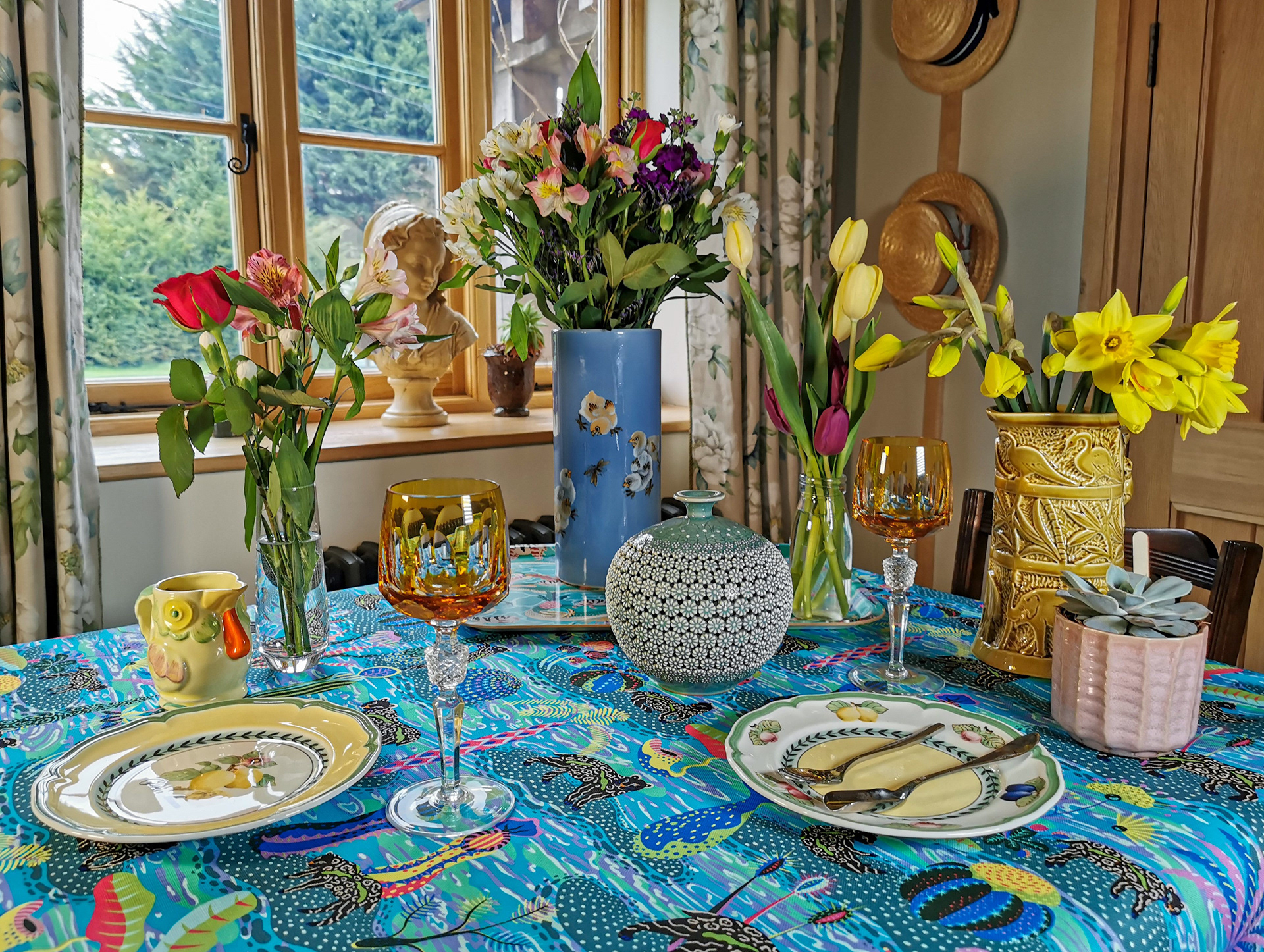 Photograph of a cottagecore tablescape showcasing a vibrant blue patterned tablecloth by Sam Wilde.