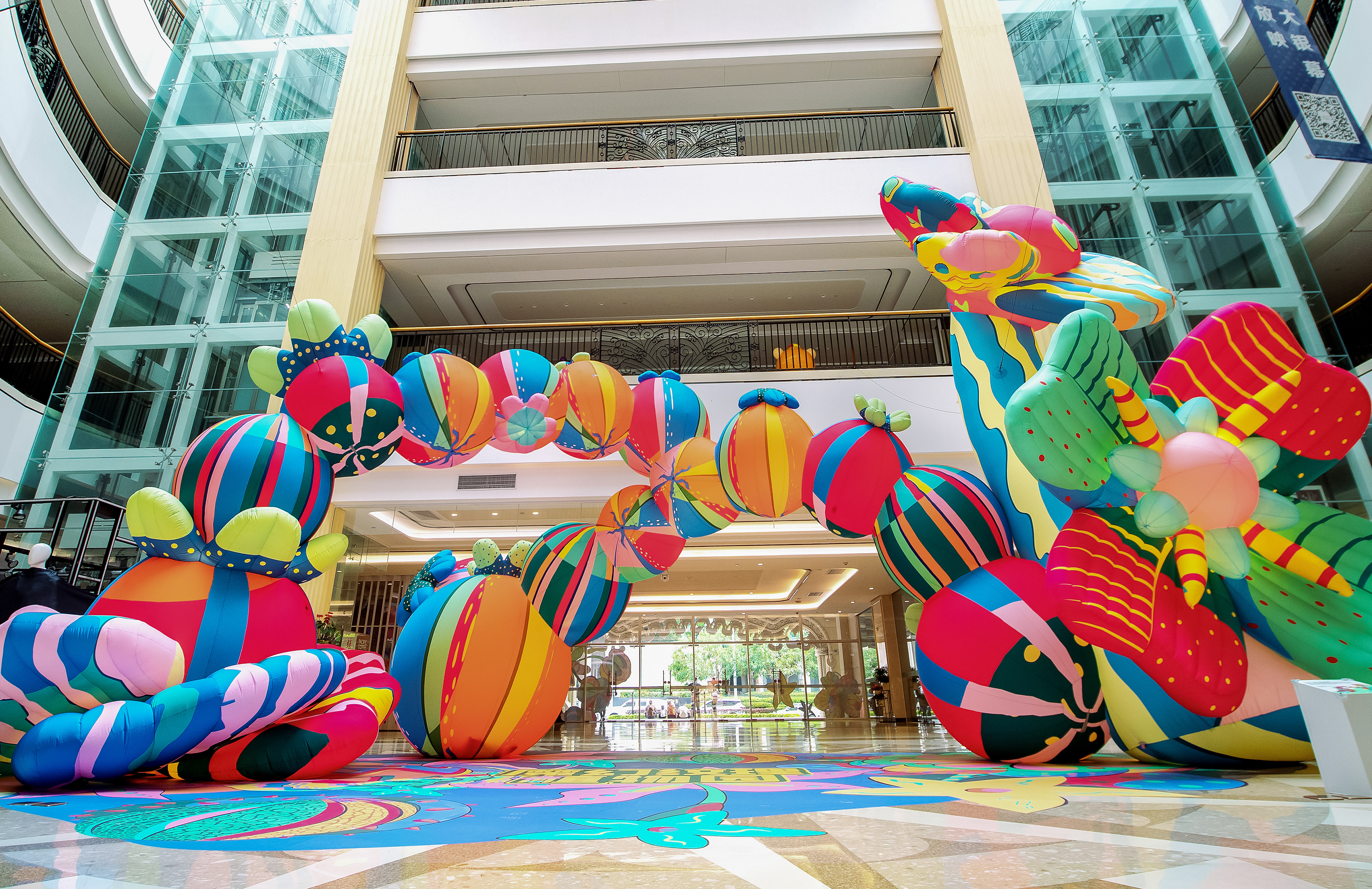 An archway designed by Sam Wilde made entirely of over-sized playful fruits and flowers.