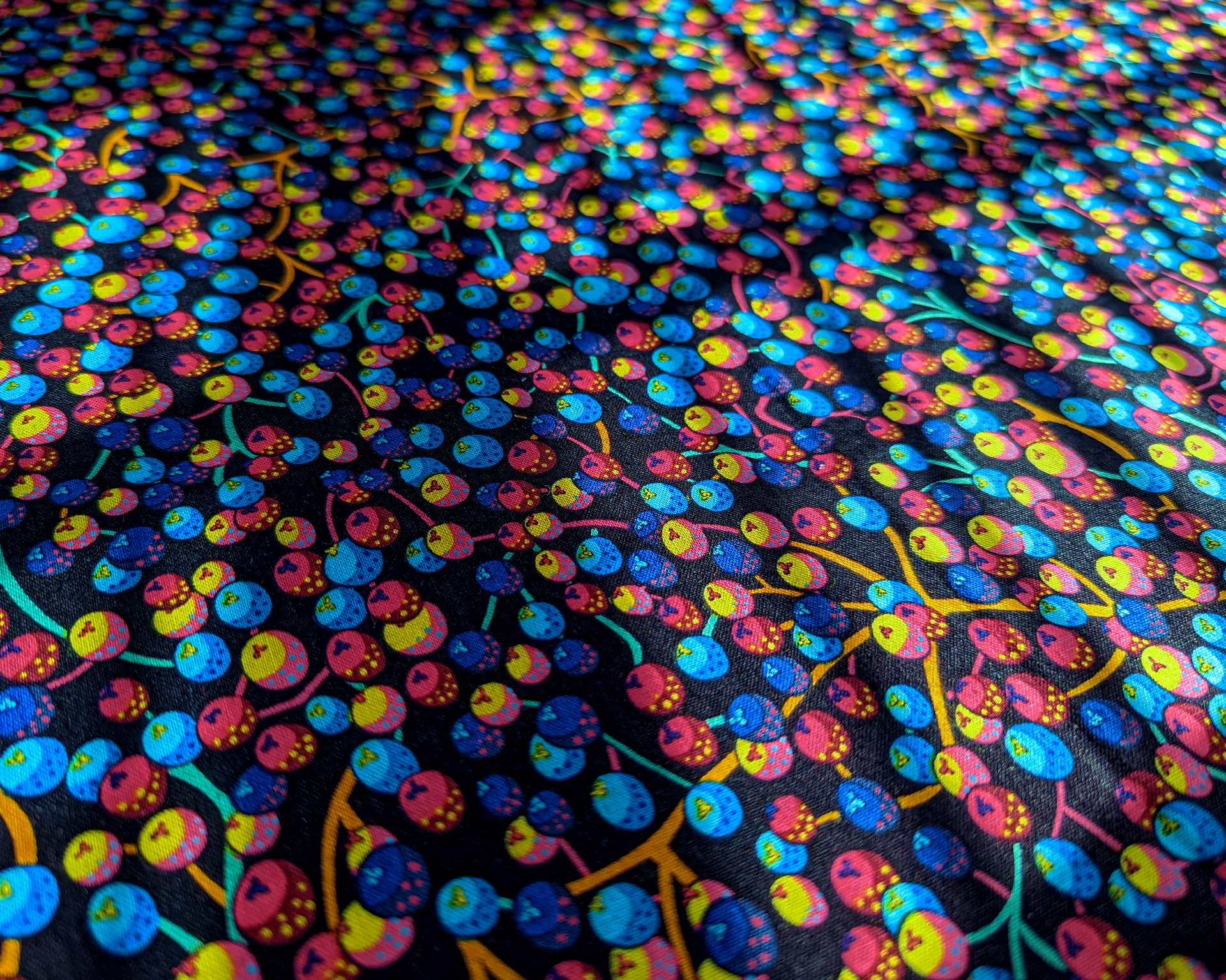 Photograph of multicoloured berry pattern on cotton fabric.