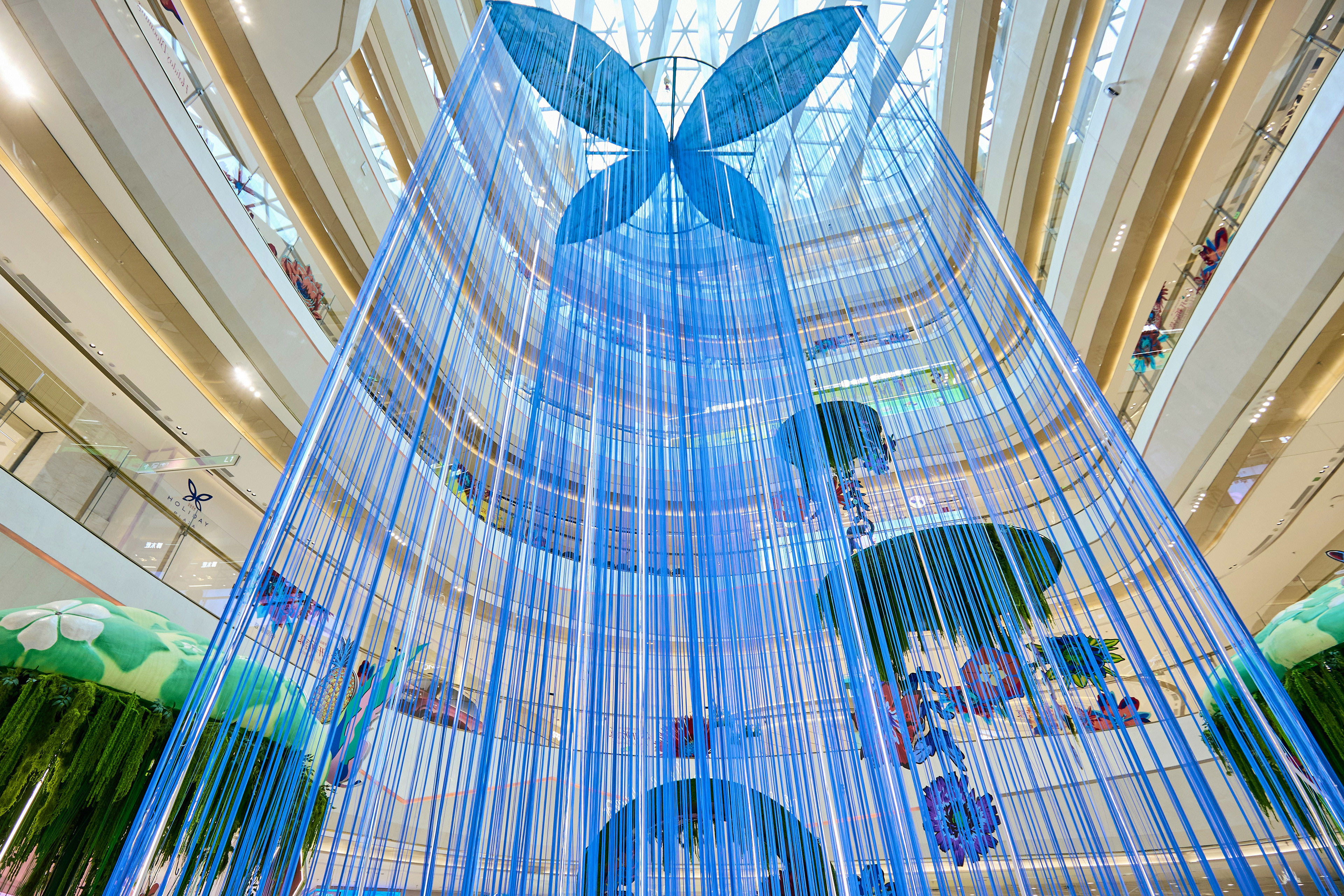 A large-scale installation in Shenzhen by Sam Wilde showing a large blue butterfly sculpture.