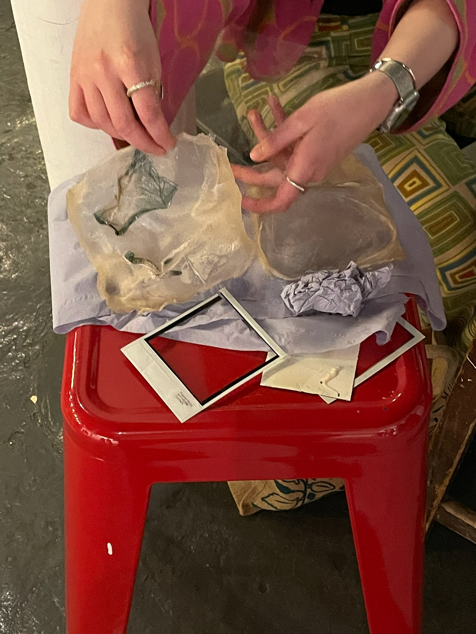 cut up polaroids and in progress bioplastic forms resting on bench